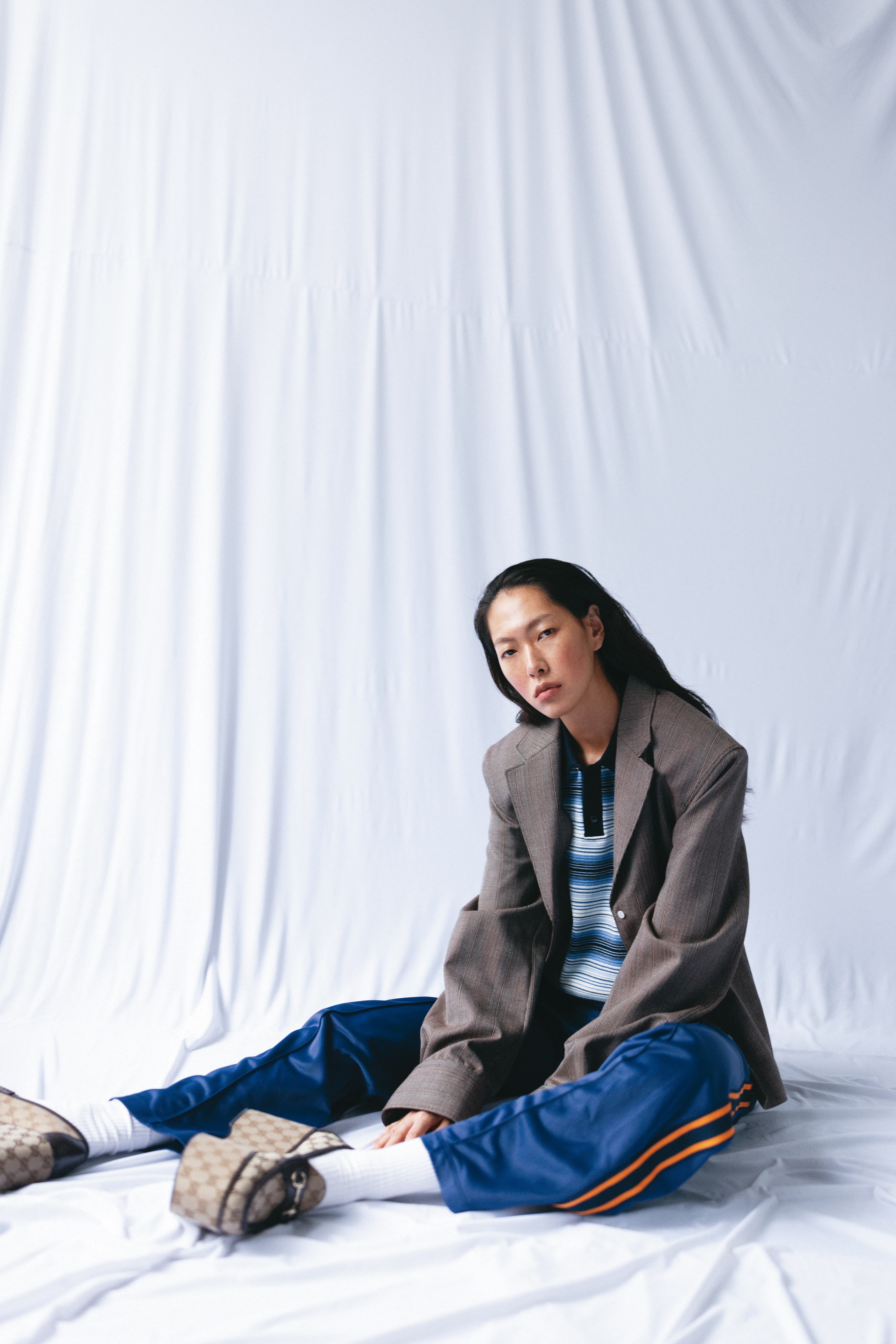 棕色西裝外套 價格店洽 by PRADA／條紋短款上衣 價格店洽 by CELINE BY HEDI SLIMANE／復古海軍藍運動長褲 NT$40,500 by CELINE BY HEDI SLIMAN／logo厚底樂福鞋 NT$46,300 by GUCCI