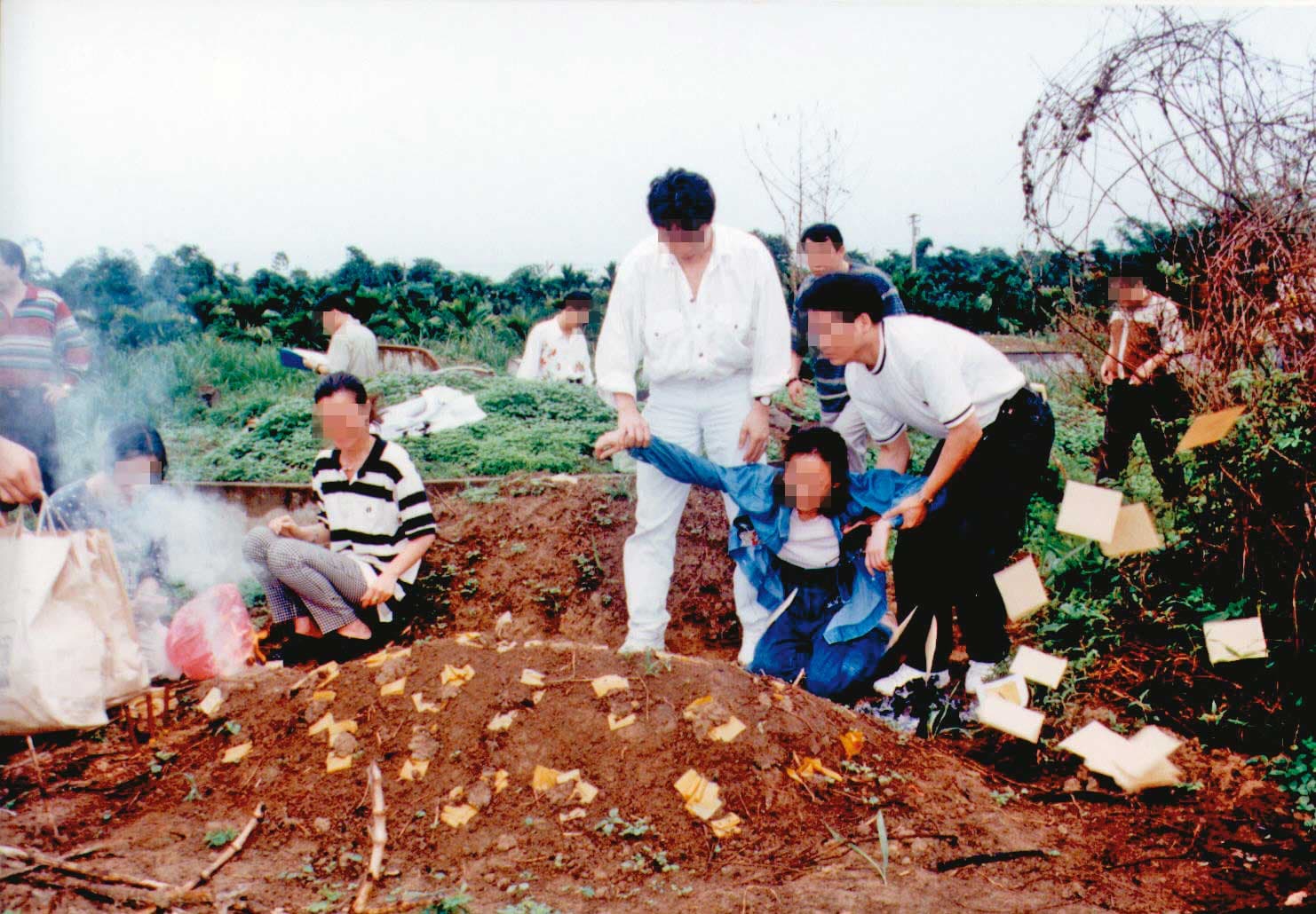 殺了丈夫的劉妻(藍衣者)重回埋屍地點,當場腿軟,還需靠警方在旁攙扶。(聯合知識庫)