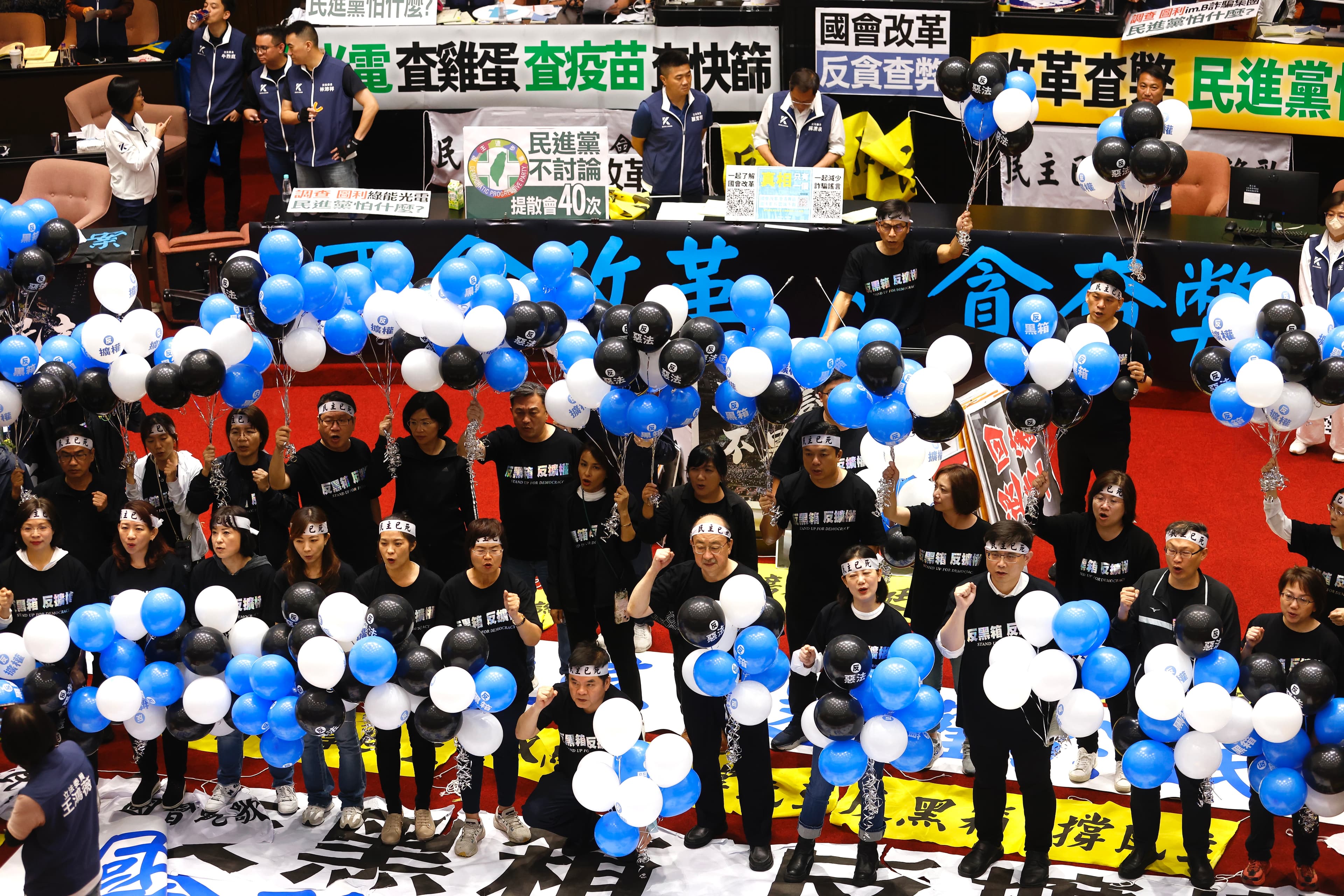 民進黨立委人手一串「藍白黑」氣球,象徵藍白黑箱的幽靈盤據在立法院上空。