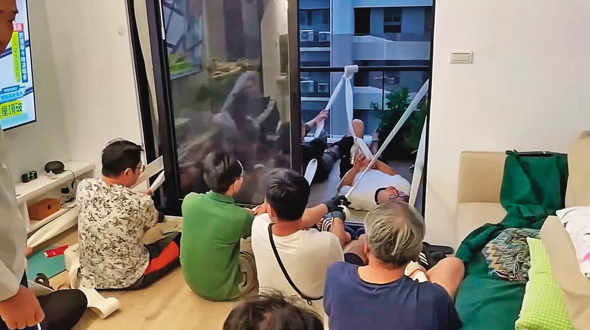 新竹某高樓住戶合力用消防水帶固定搖搖欲墜的玻璃陽台。(翻攝爆料公社)