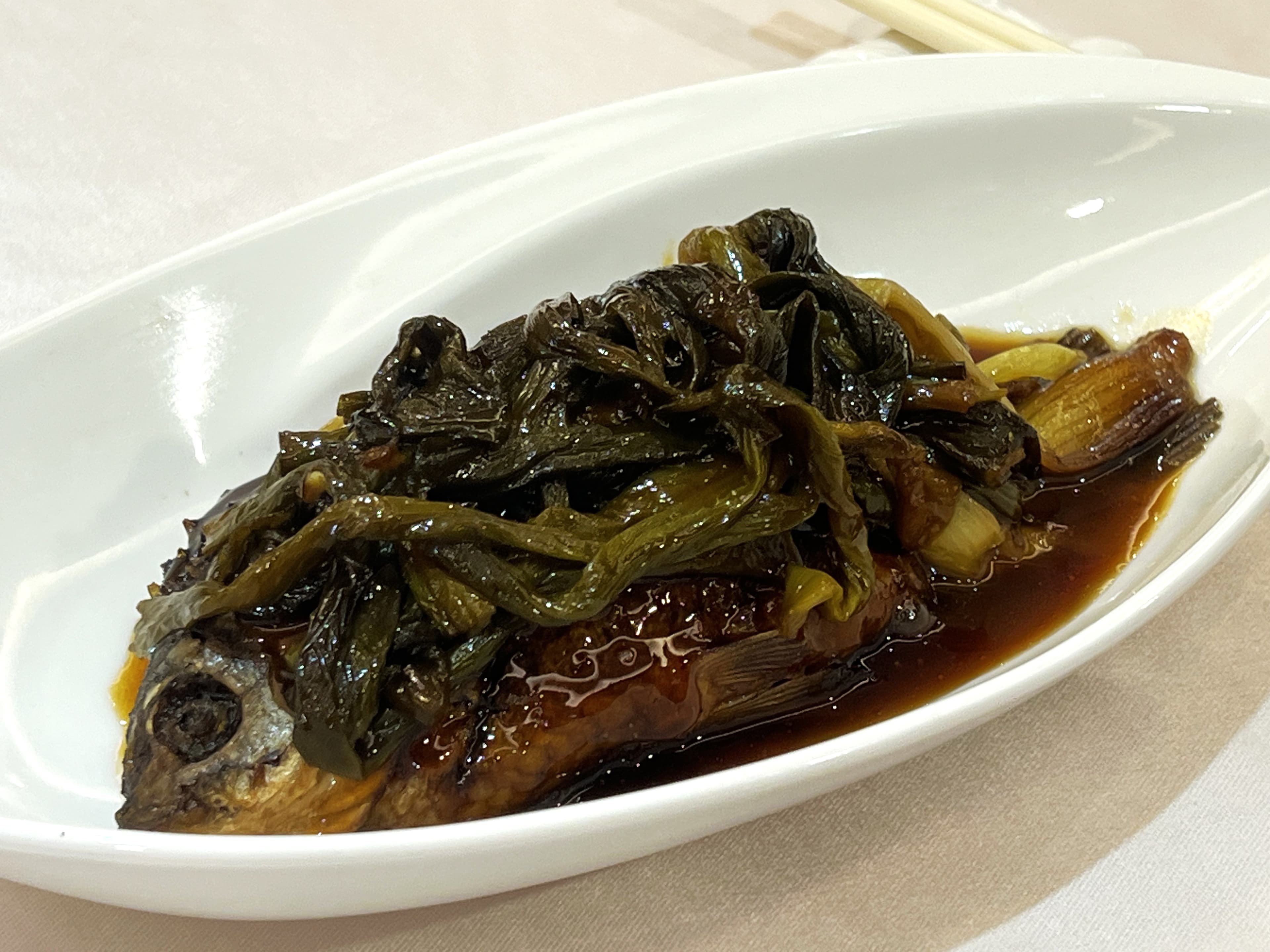 大尾帶卵的「蔥烤鯽魚」非常入味,上頭鋪滿㸆過的青蔥。