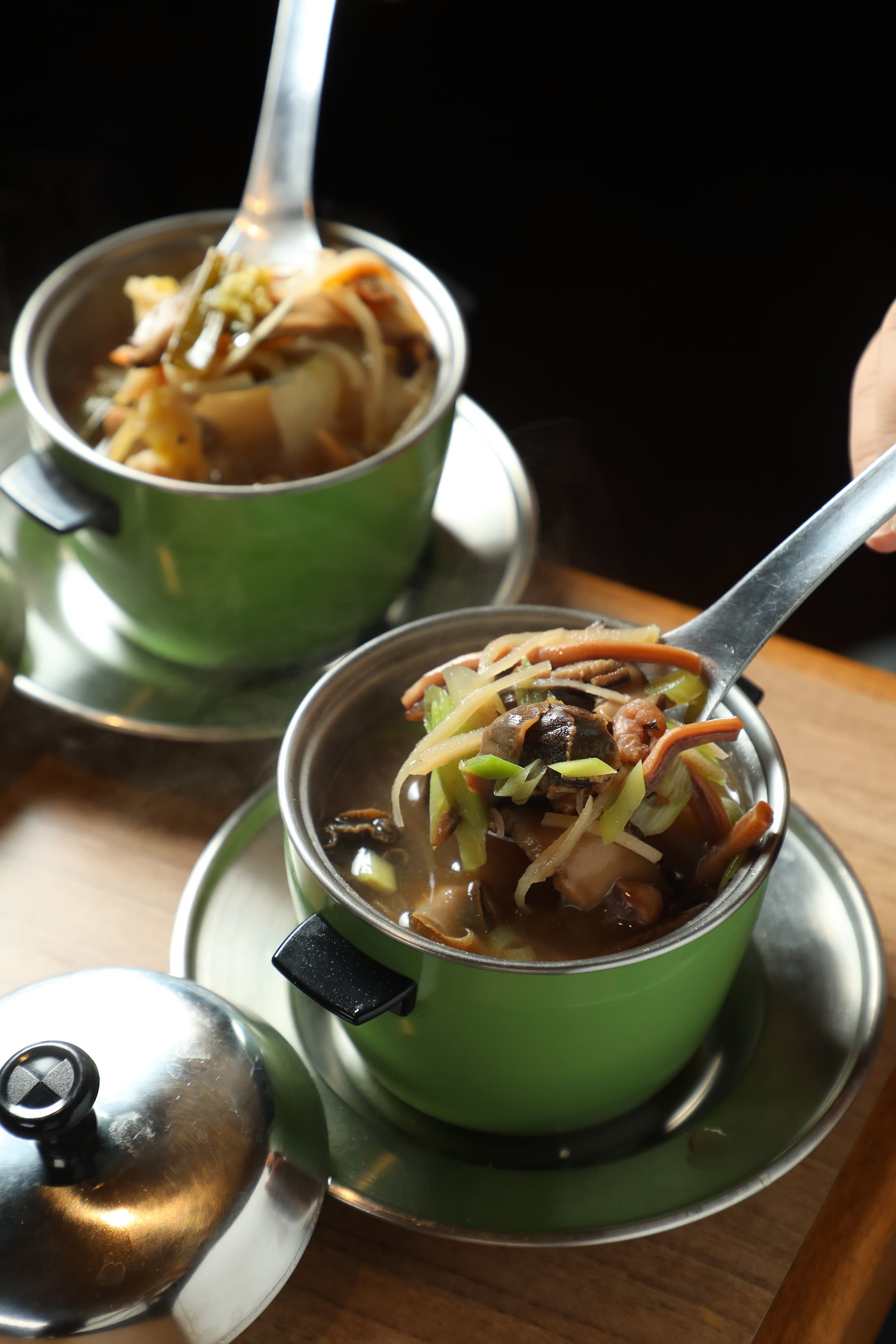 「魷魚螺肉蒜」(前)充滿乾貨的鮮甜海味;「菜尾湯」(後)是早年辦桌菜的壓軸。(皆180元/份)