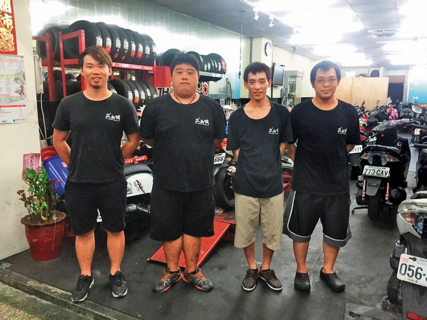 9年前林弘毅(左1)在中和開第一間二手機車店,當時維修、改裝、美容都做,資金有限,店面較小。(林弘毅提供)