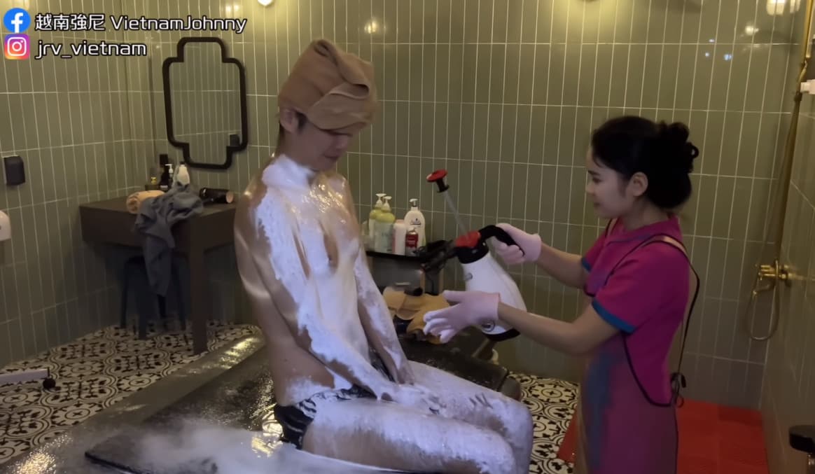服務人員拿噴霧器在強尼全身噴上泡沫。（翻攝自YT頻道「越南強尼VietnamJohnny」）