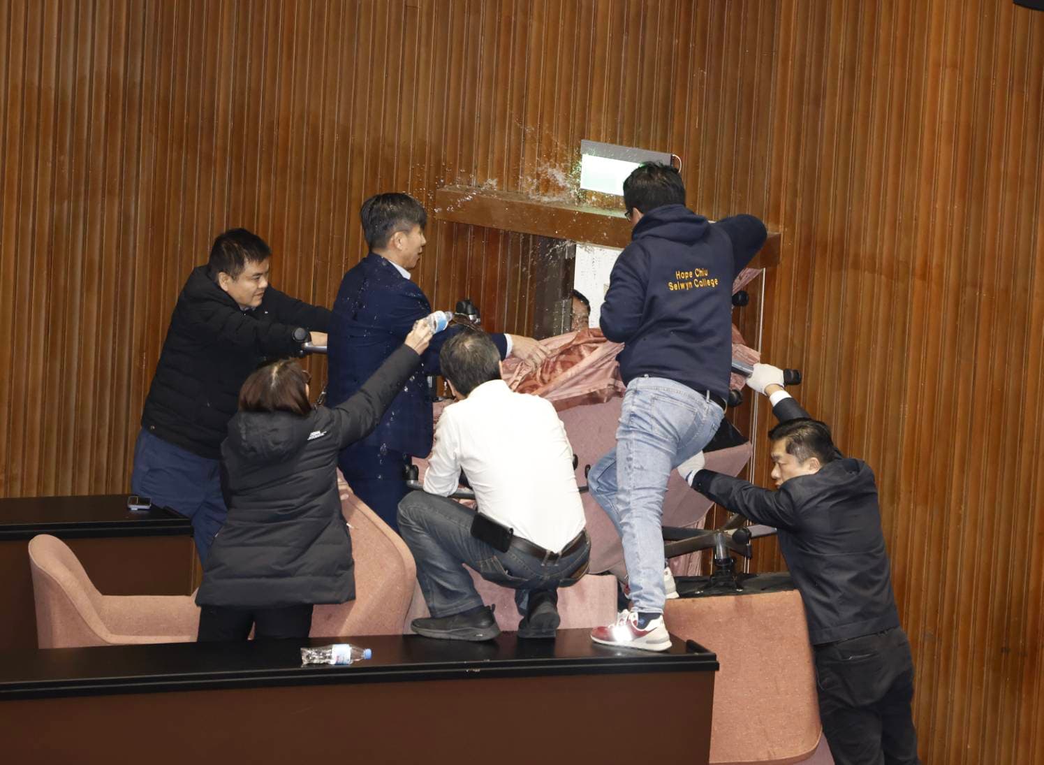民進黨立委為了阻止藍營修法,封住議場大門,還潑水防止藍委進入。
