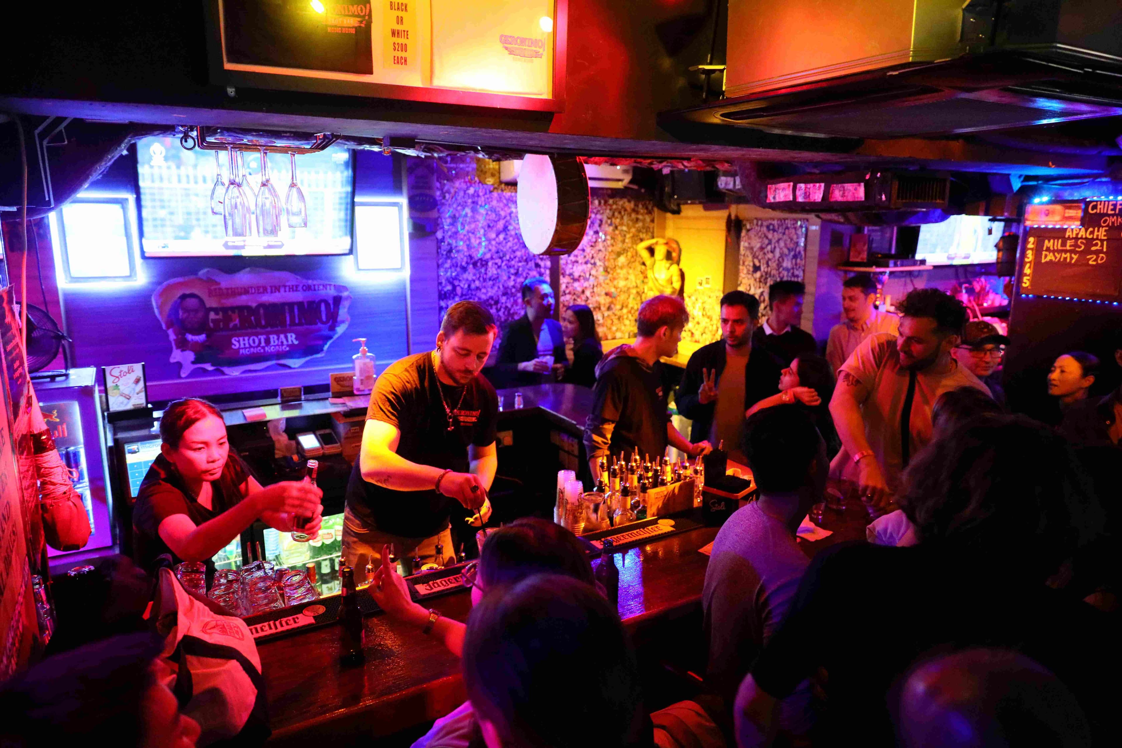 酒吧裡人聲鼎沸,Bartender熟練地調酒招待客人。