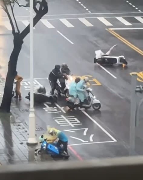 高雄港前鎮區路上，幾名騎士不敵強風倒地，模樣十分狼狽。（翻攝自記者爆料網）