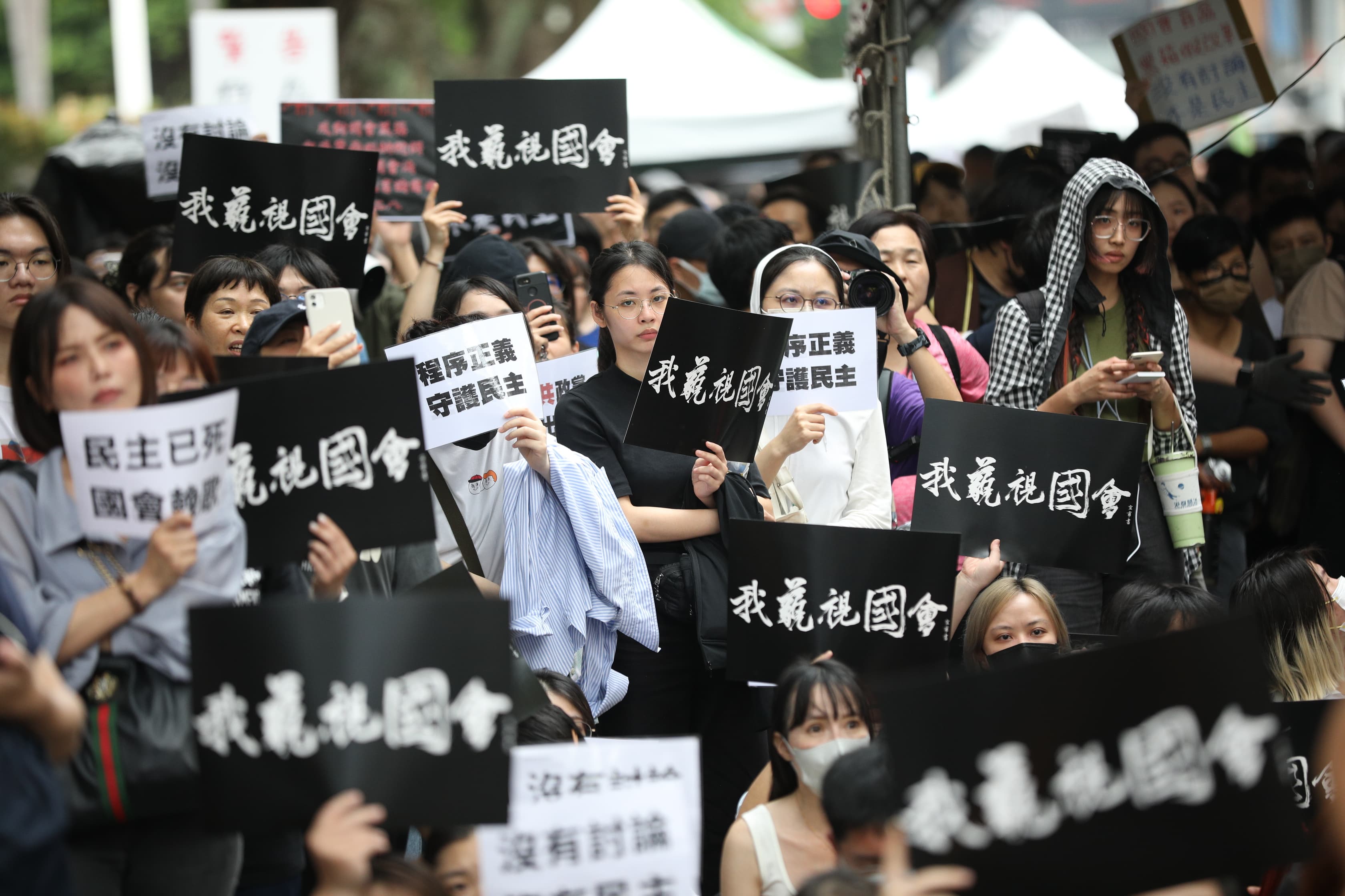 立法院外今聚集大批抗議民眾,痛批藍白以人數優勢強推法案,訴求「沒有討論,不是民主」。