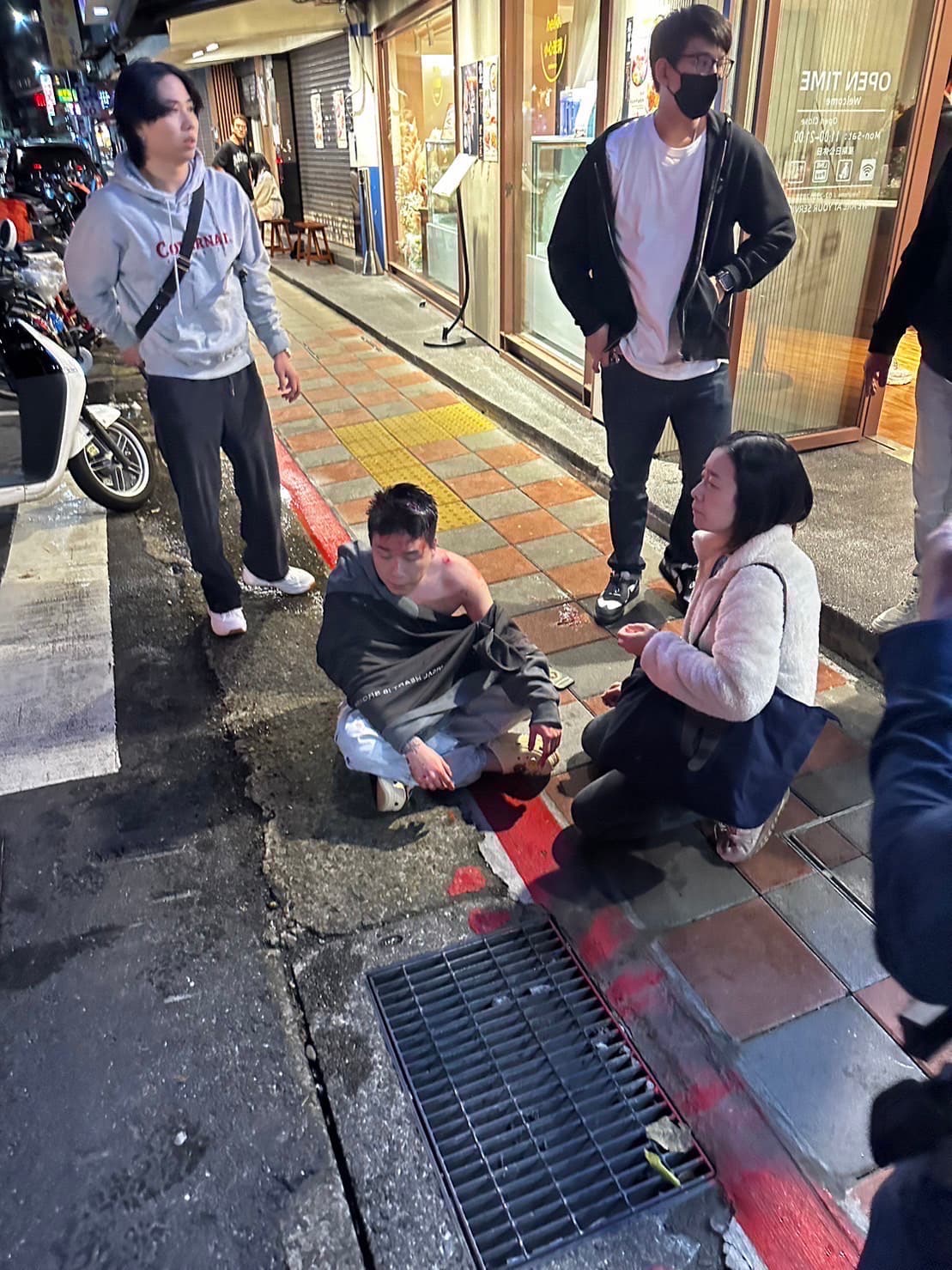 被暴打後,Toyz狼狽地坐在街邊。(翻攝自記者爆料網)