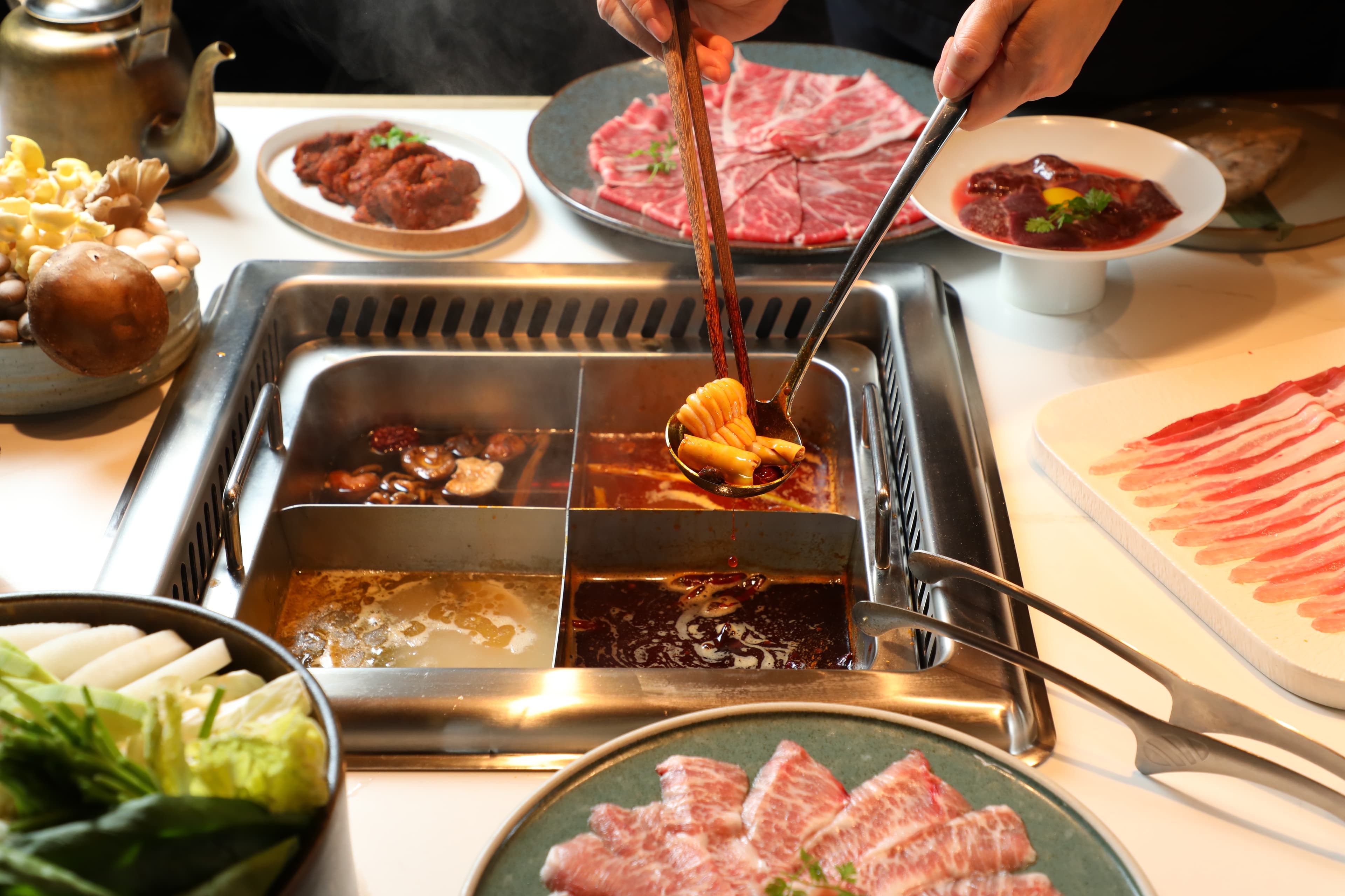 點四宮格可把「重慶牛油鍋」(右下,320元/份)「酸菜魚鍋」(左下,220元/份)「番茄鍋」(右上,240元/份)和「蕈菇鍋」(左上,180元/份)一網打盡。