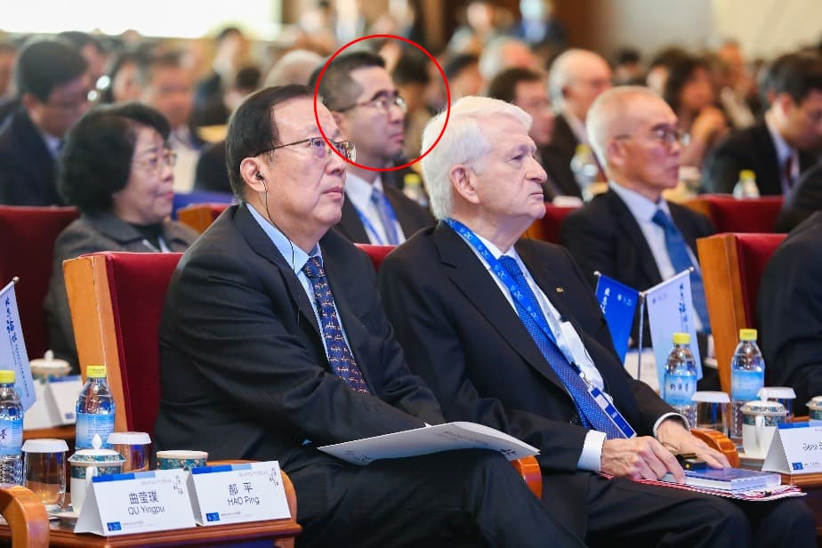北京論壇的官媒報導照片中,特寫中國日報社社長兼總編輯曲瑩璞及北大書記郝平合照,蕭旭岑〈紅圈者〉就在二人位置後方。(翻攝自北京大學新聞網)