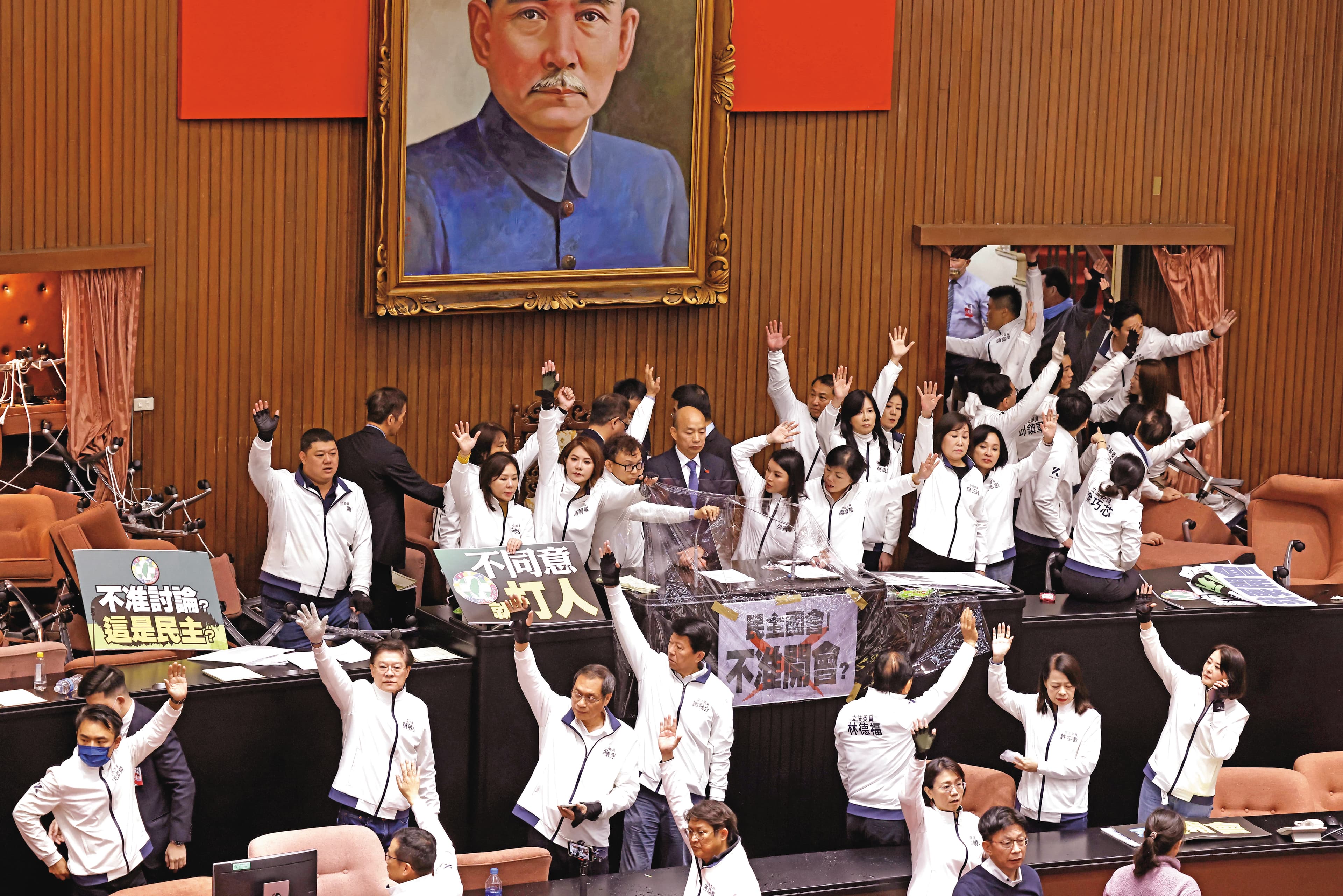 藍委奪回議場主席台後，在立法院長韓國瑜周圍架起人牆，確保議事順利進行。