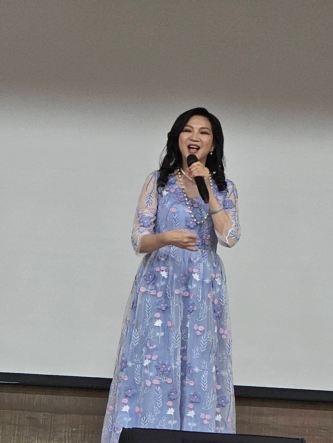 小百合(周月綺)獻唱〈小城故事〉,並為張任芝蘭師母獻花。(台北市電影委員會提供)