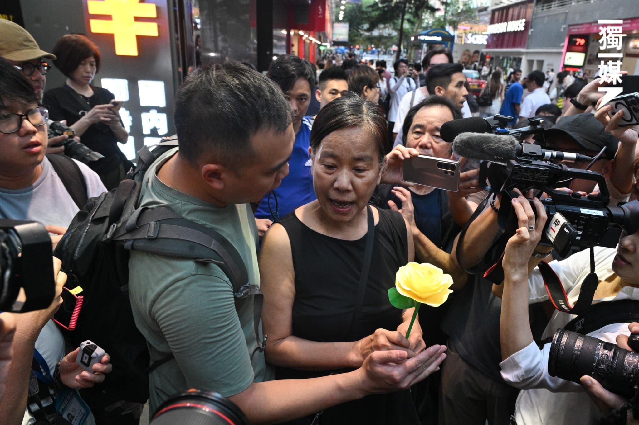 陳寶瑩手持摺紙花也遭警方關切、強制帶走。(翻攝自臉書獨立媒體 inmediahk.net)