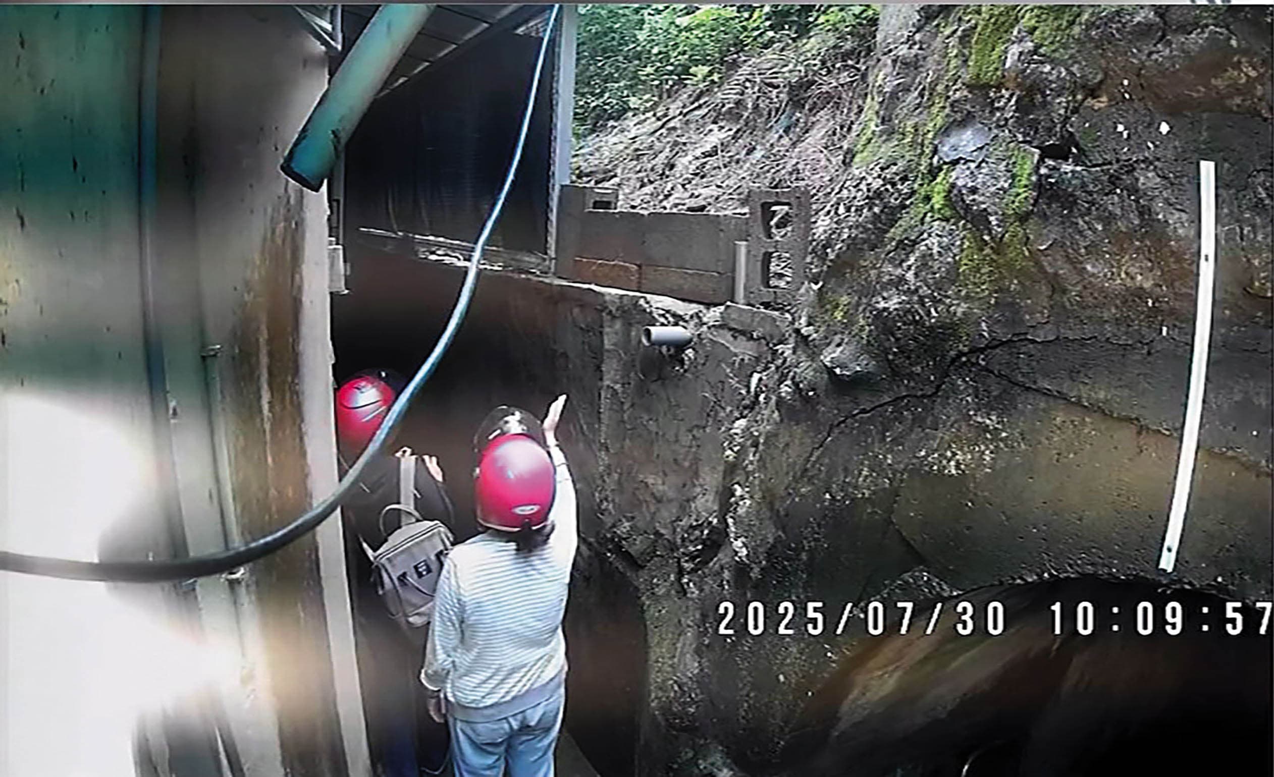 2名戴安全帽的軍備局人員推開鐵門,擅自闖入民眾的住家範圍。(投訴人提供)