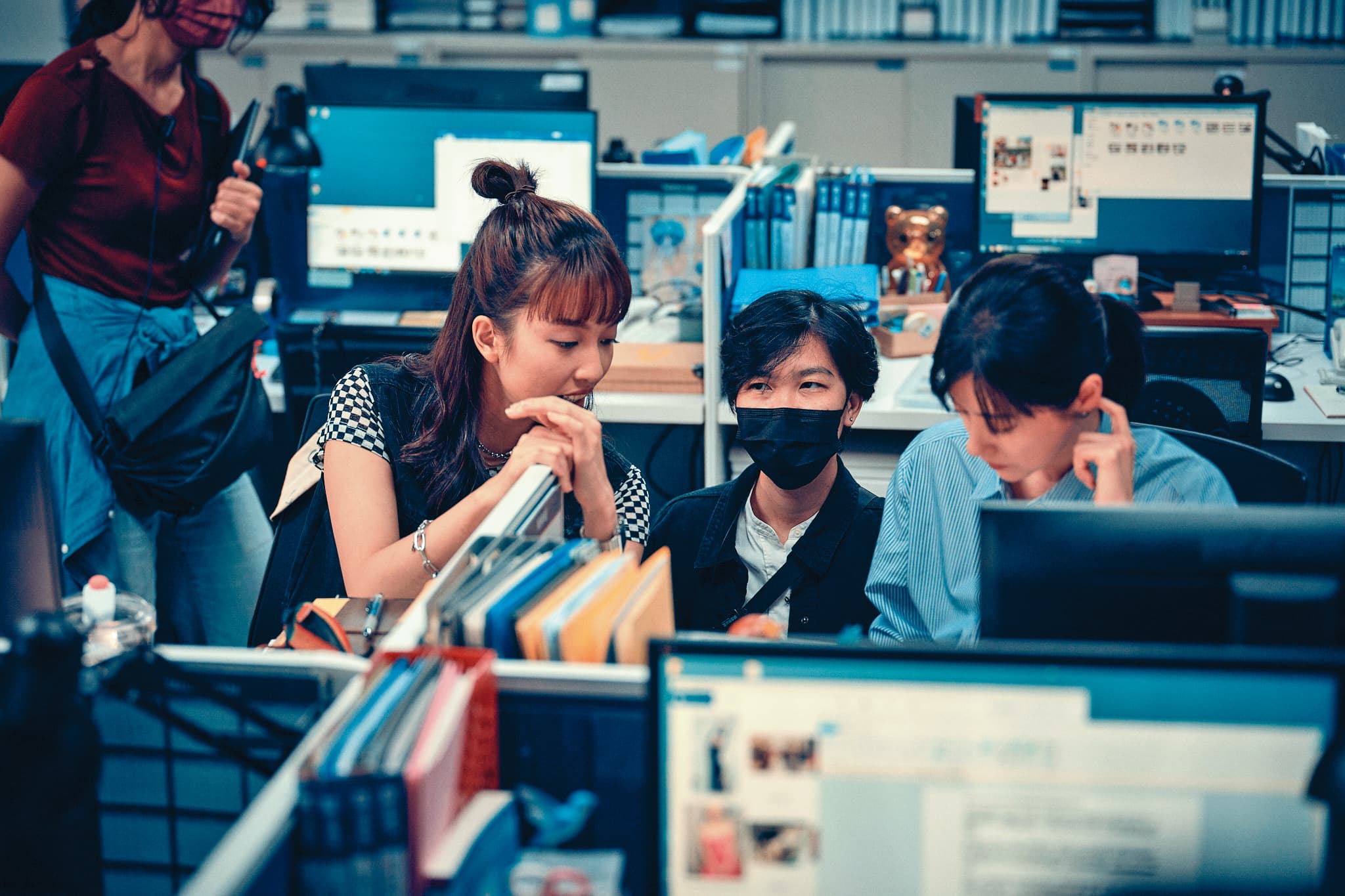 導演梁秀紅（中）與演員林予晞（右）及王渝萱（左）在拍攝現場討論劇本。（鏡文學提供）