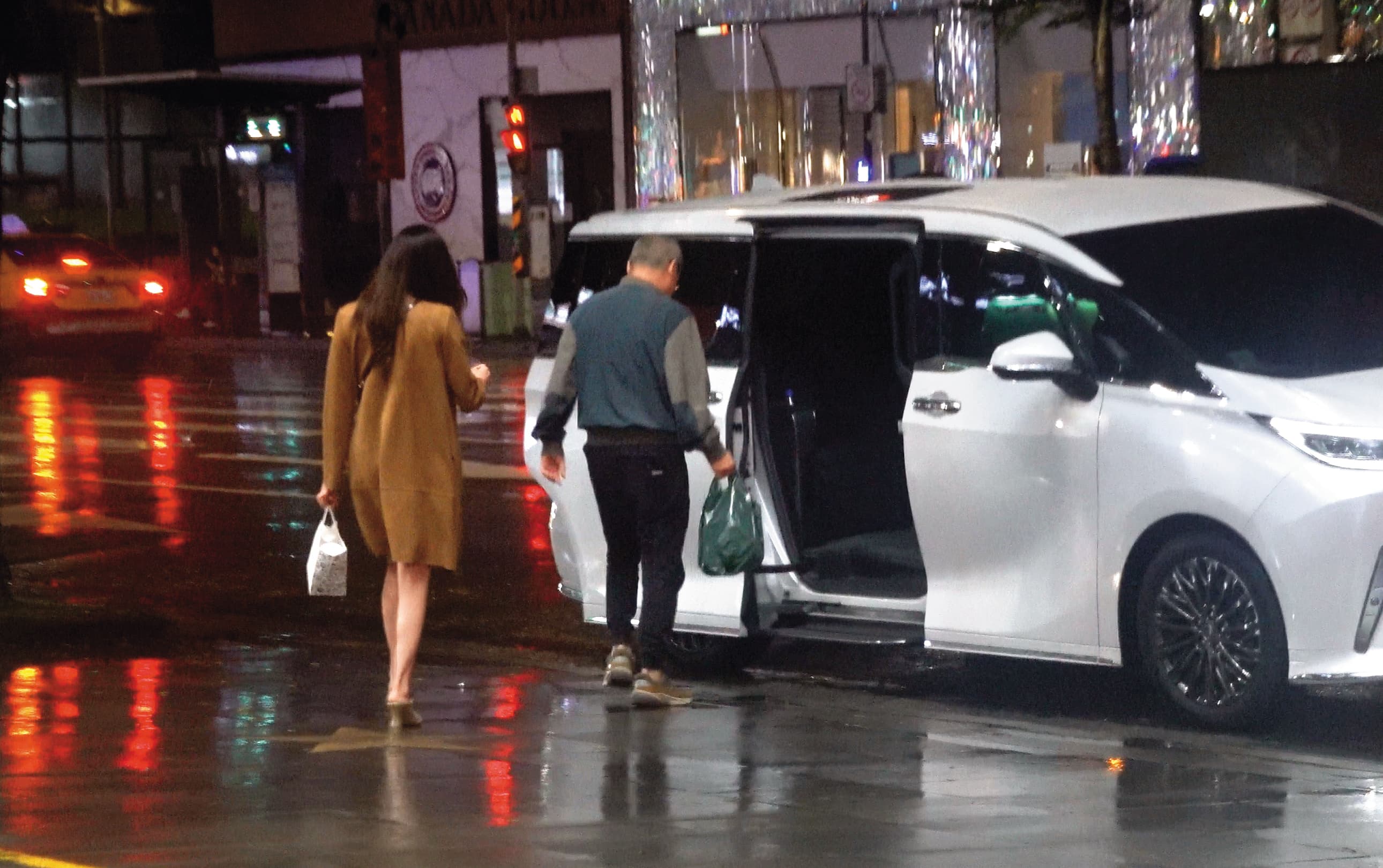 22:56 黃立成（右）和女伴（左）走到路邊時，豪華保母車已經抵達接送。