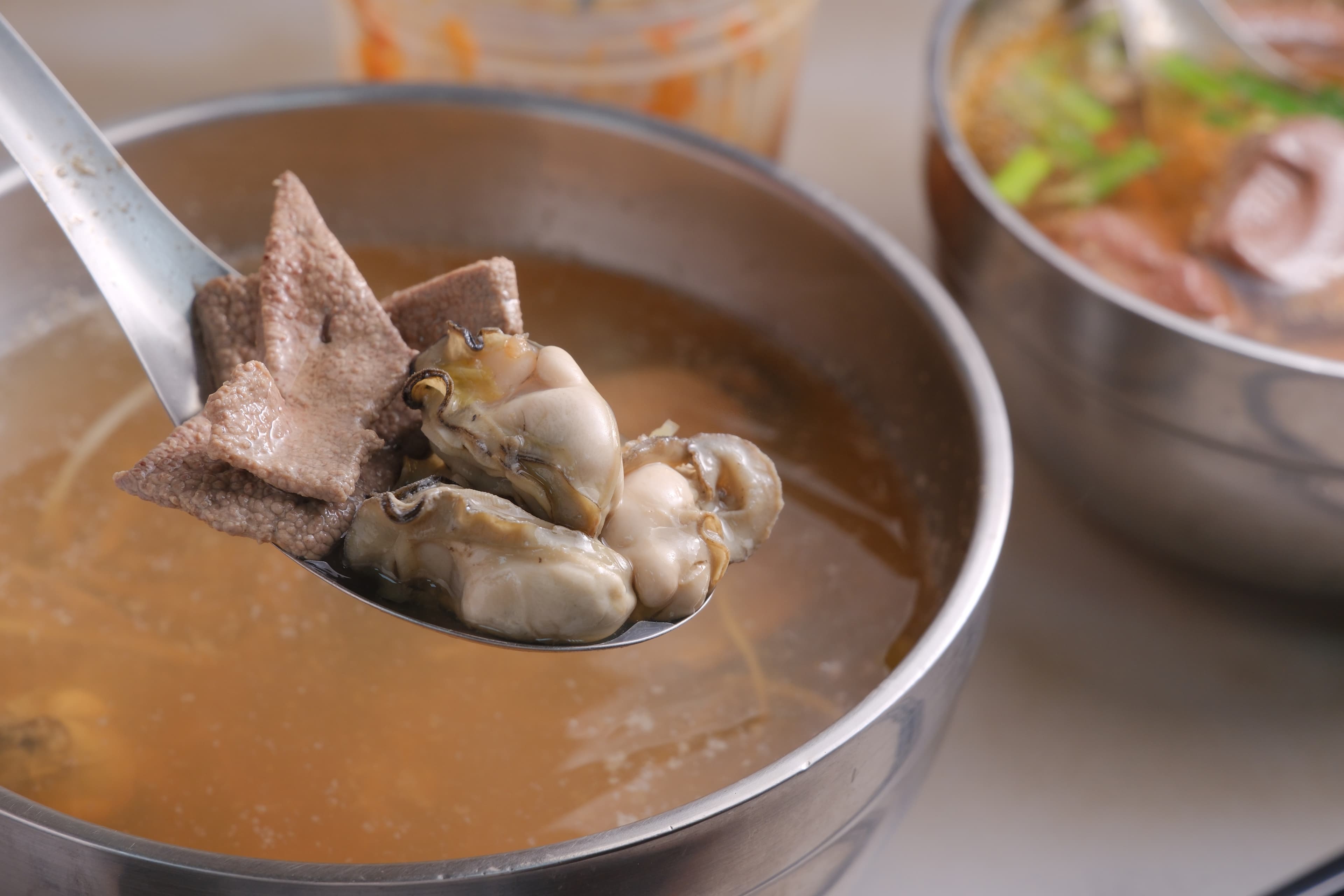 用肥美蚵仔與厚切豬肝熬煮的「海陸湯」，是許多老饕心中不到百元的能量補給。（彭仁義攝）