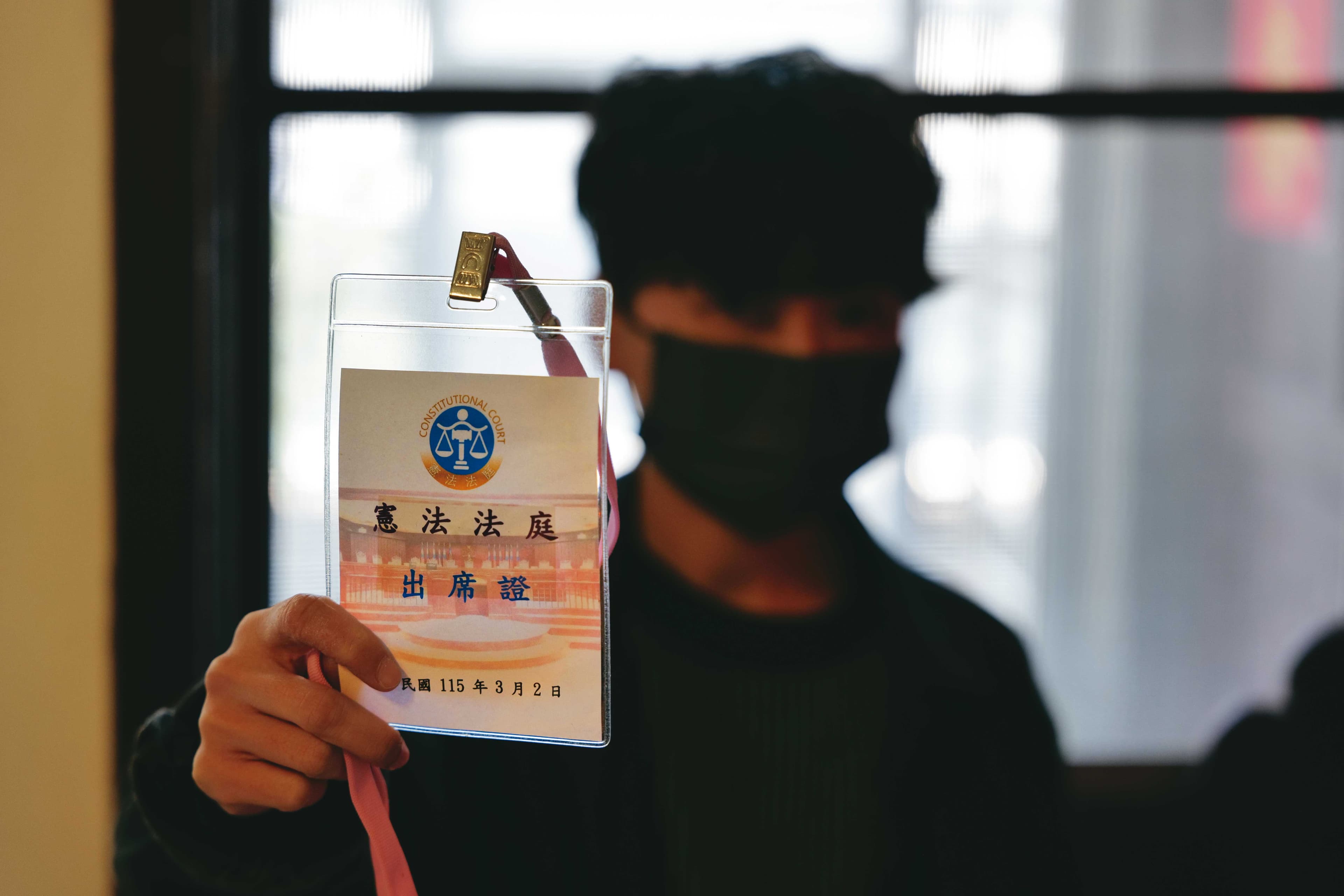 J拿著3月2日憲法法庭不公開說明會的出席證,她正在等待釋憲的結果。