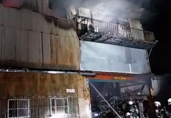 消防局出動百餘名救災人員與無人機、救災機器人趕抵南港火場，全力阻止火勢向鄰近林木蔓延。（翻攝畫面）