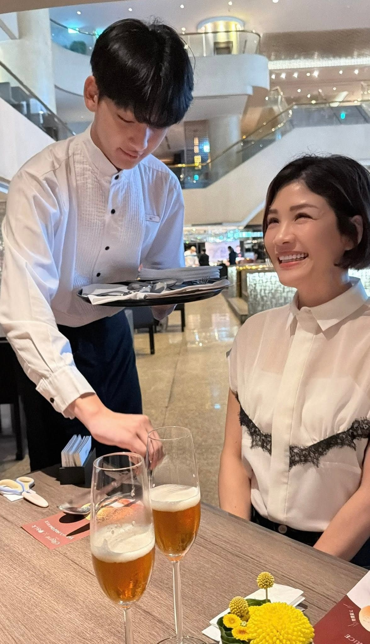 關義穿上服務生制服,幫母親擺放餐具。(翻攝蔣雅淇臉書)
