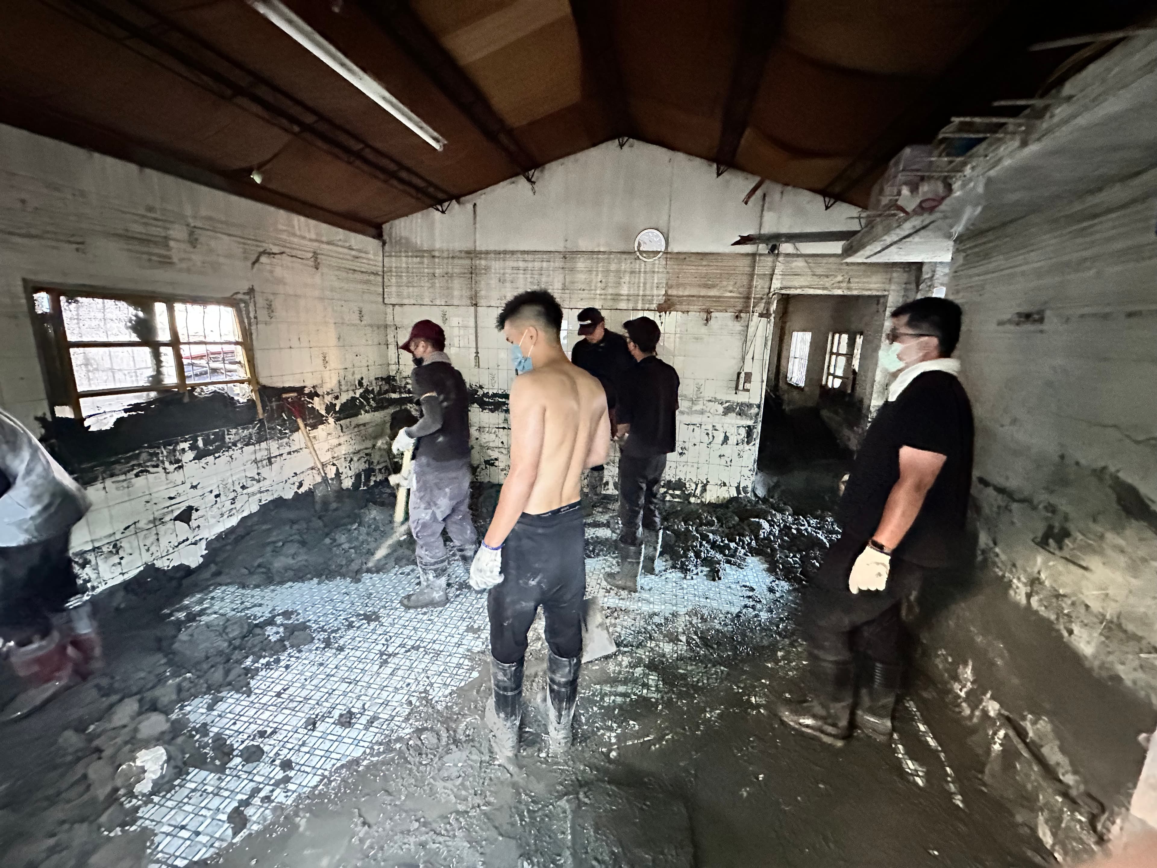 屋內時鐘下明顯的水線，屋內外積著泥土，阿美族部落青年聯手鏟子超人展現清淤高效率。