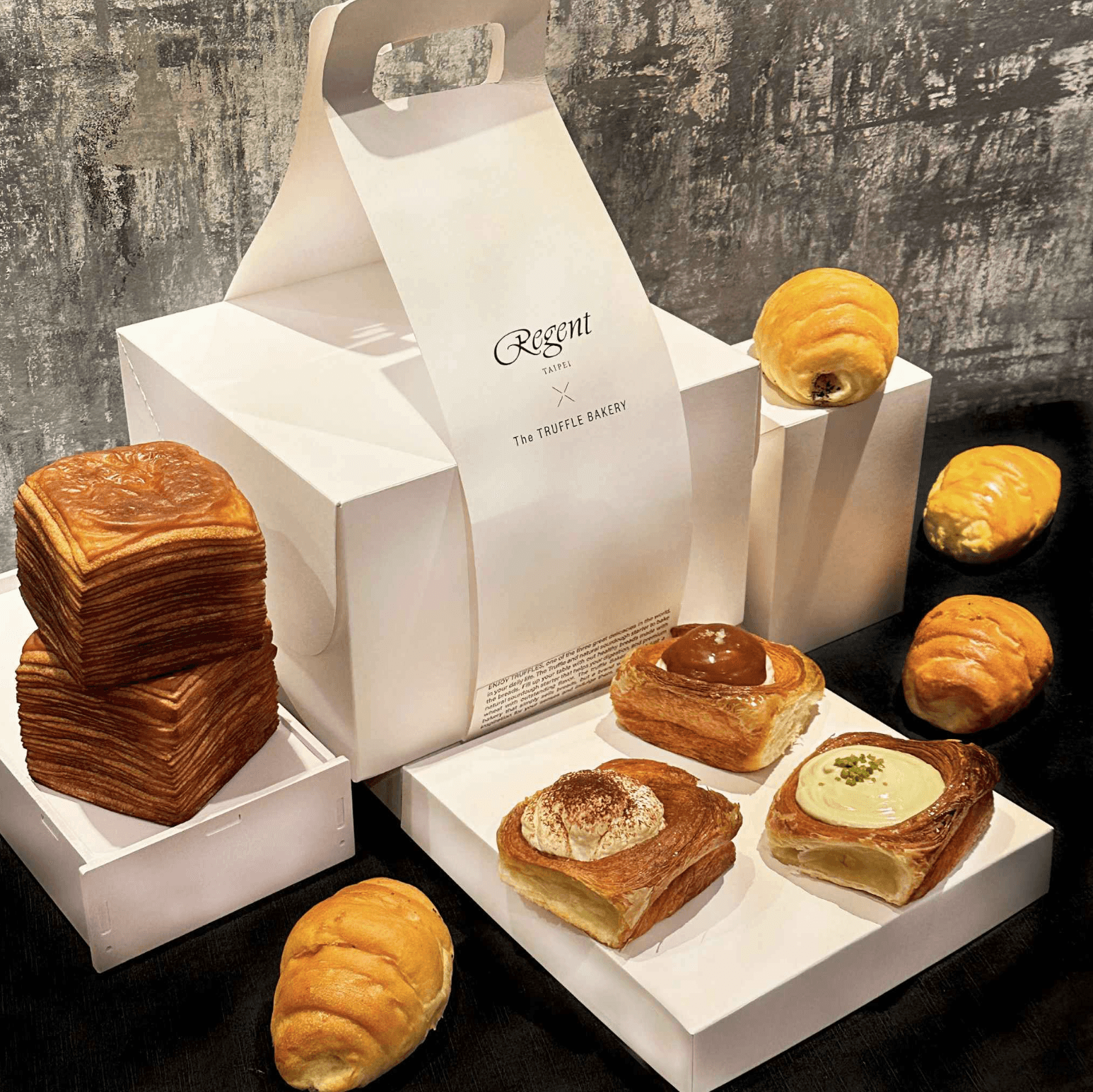「The TRUFFLE BAKERY 美饌禮盒 Gourmet Gift Box」內含「經典奶油紙巾吐司」與「巧克力紙巾吐司」兩種口味;以及「岩鹽奶油捲」「松露岩鹽奶油捲」各2入;與「開心果倫敦麵包」「焦糖海鹽倫敦麵包」「提拉米蘇倫敦麵包」。(1,580元/組,晶華酒店提供)