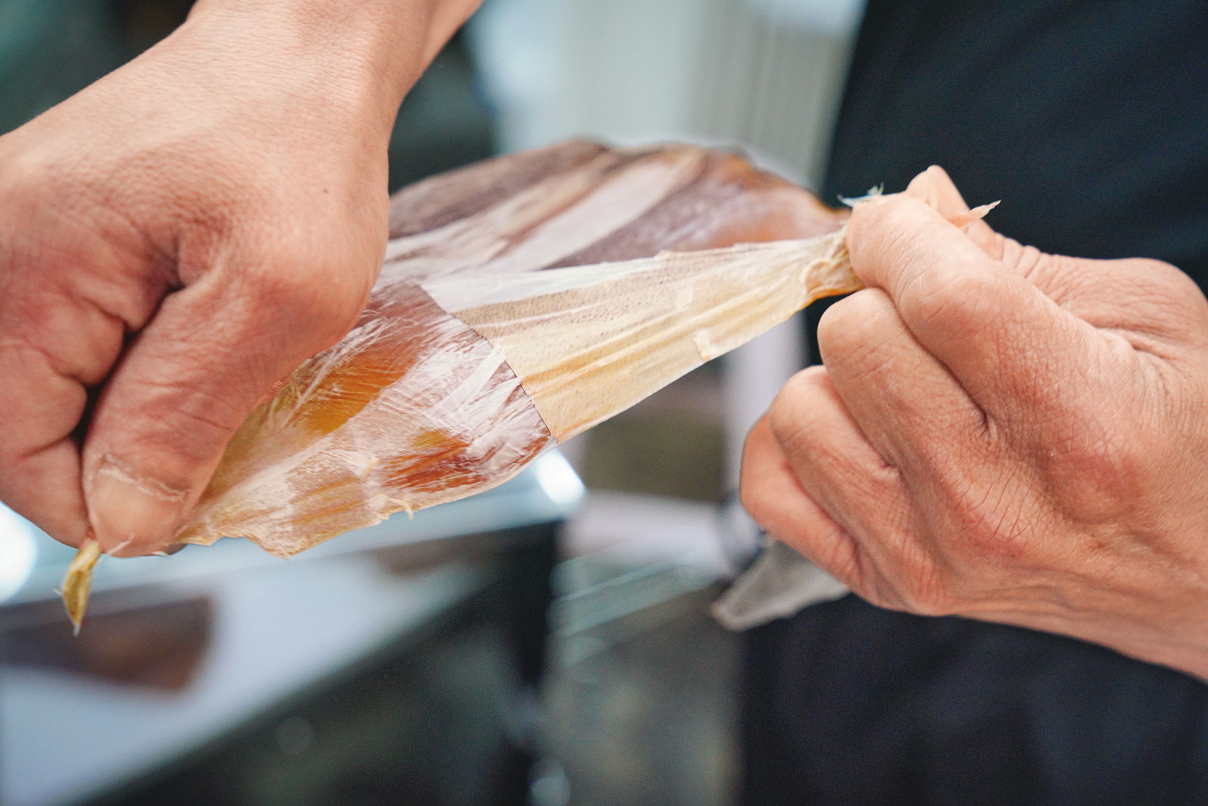製作魷魚片,魷魚得先熟成,再手工去皮。