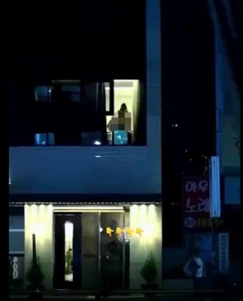 一對男女在窗邊激情愛愛,室內燈光全亮,從窗外可清晰看見火辣春光。(翻攝影片)