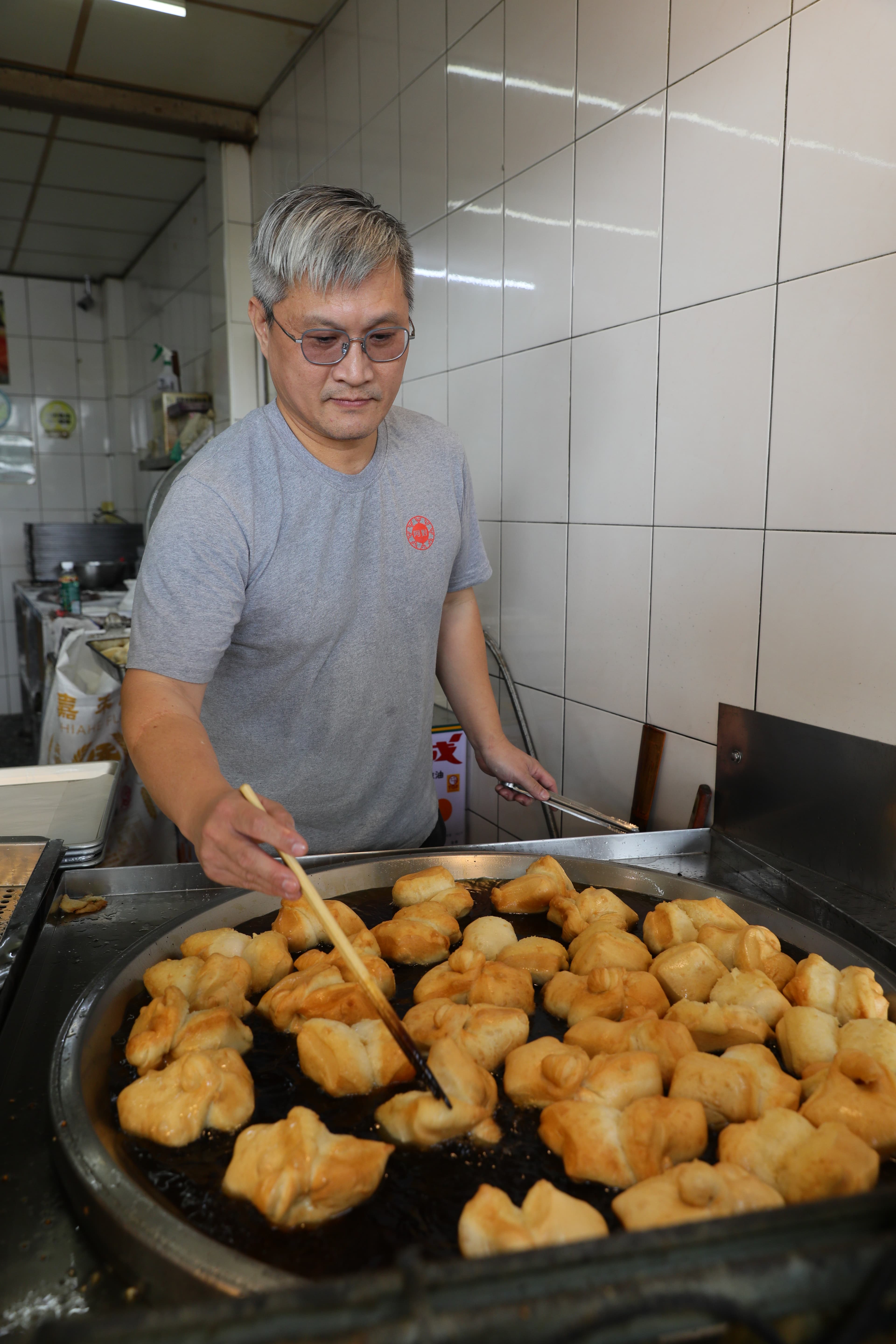 老闆熟練的翻動鍋中的雙胞胎,油溫需超過攝氏170度才能將外皮炸得又香又酥。