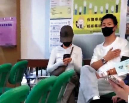 10/22 18:21 民眾直擊竇驍(右)與何超蓮(左)現身台大急診室候診,男方左手背貼著紗布,右手撫胸口,但女方似乎不擔心地滑著手機。(讀者提供)