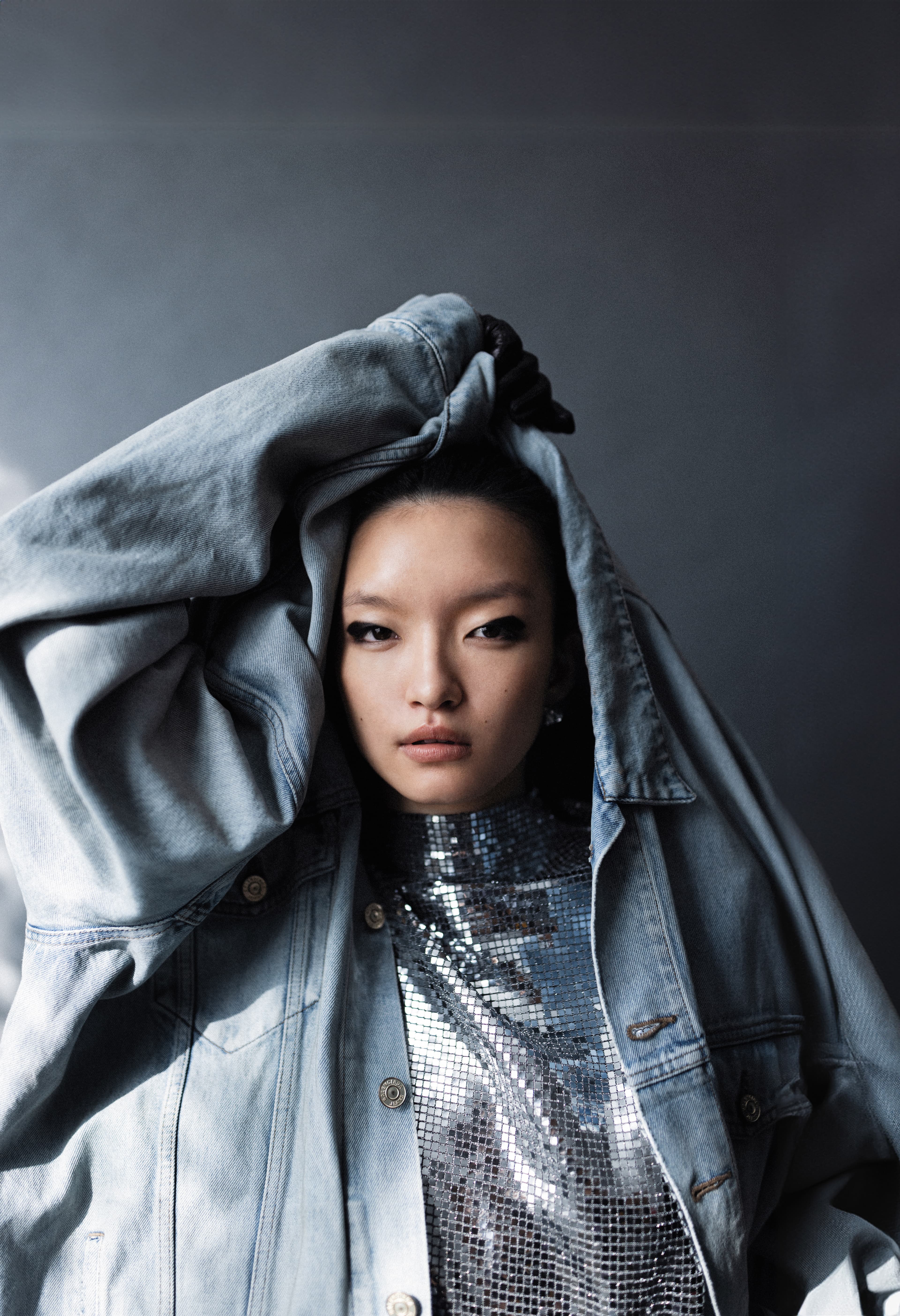 丹寧外套NT$65,000 by BALENCIAGA；銀色金屬感布料上衣 NT$7,490 by maje；銀色耳環 NT$23,000 by LOEWE；Steph黑色小羊皮手套 價格店洽 by Chloé。