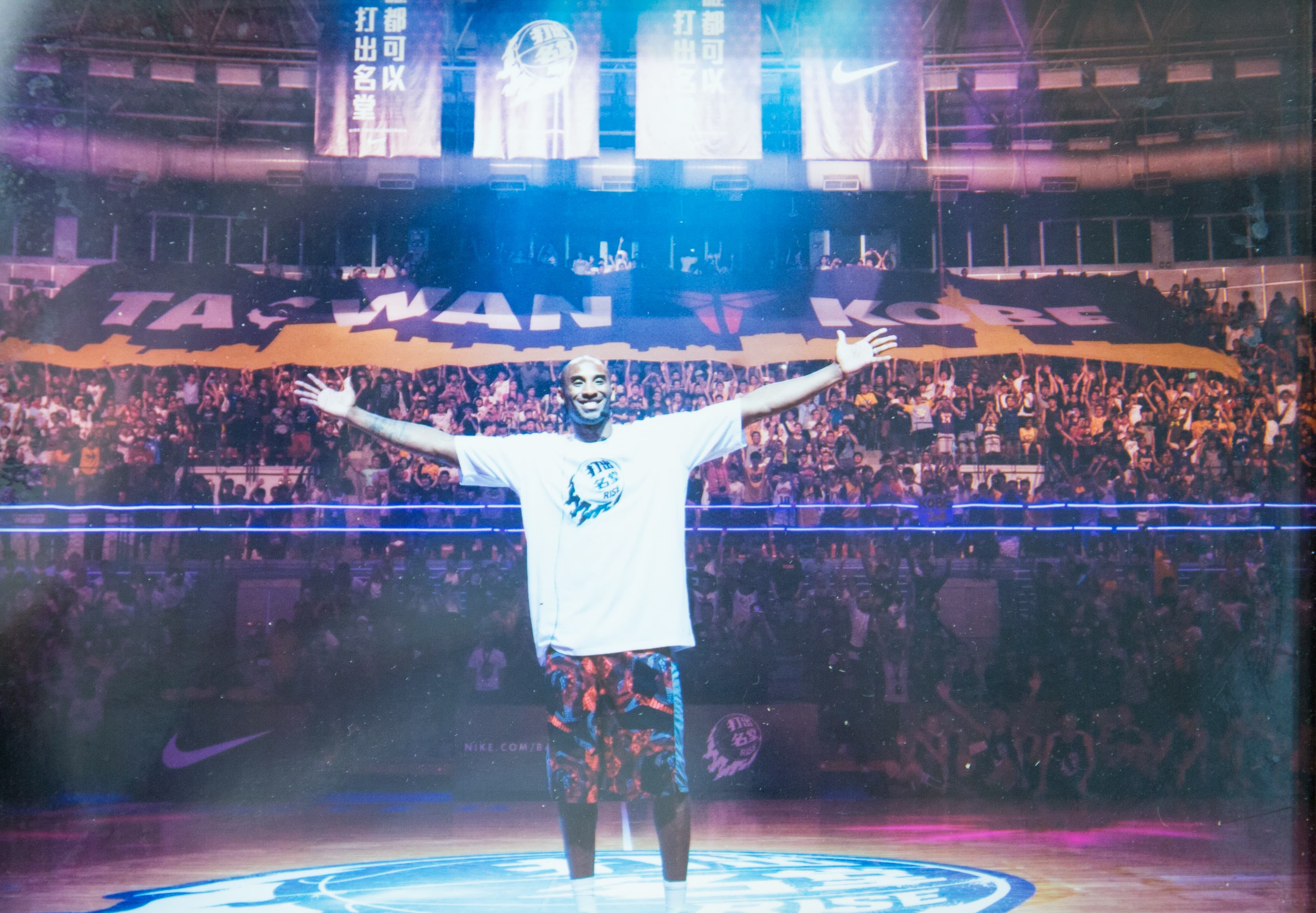 過去NBA球星Kobe Bryant來台時,展逸曾為他製作一幅「Taiwan loves Kobe」的巨型布幕,讓他欣喜要求合影。(展逸提供)
