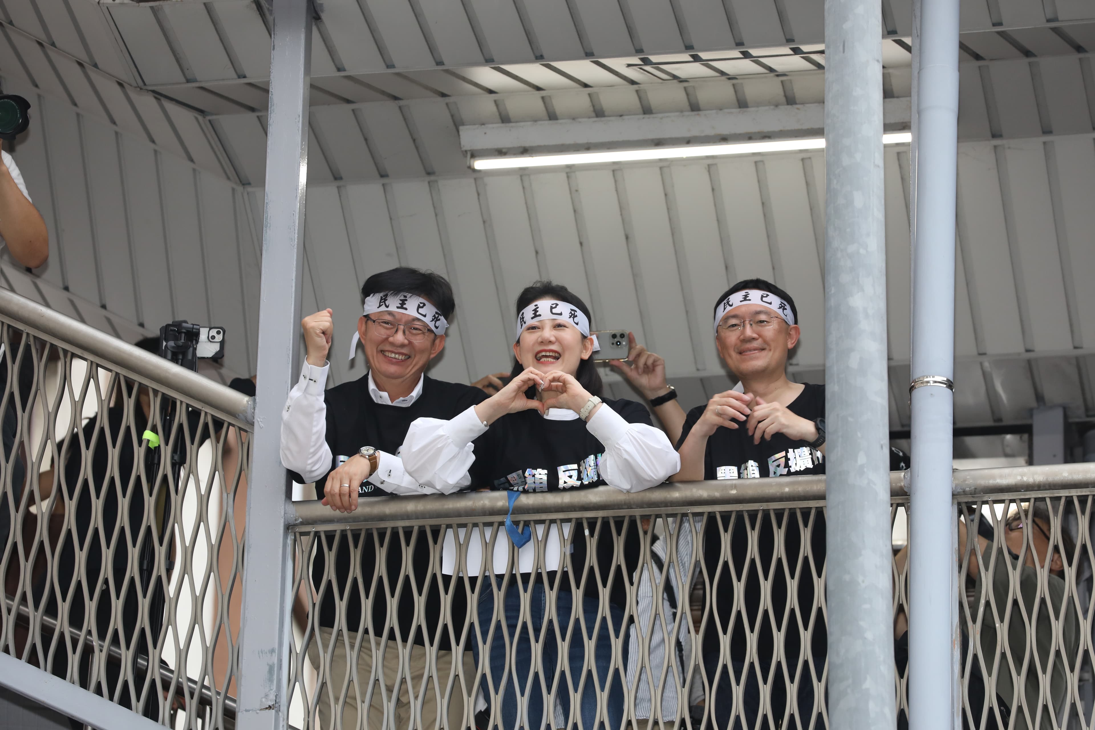 民進黨在天橋上感謝場外10萬人並肩集結聲援,吳思瑤(中)也手比愛心,謝謝民眾深夜陪他們站到最後。