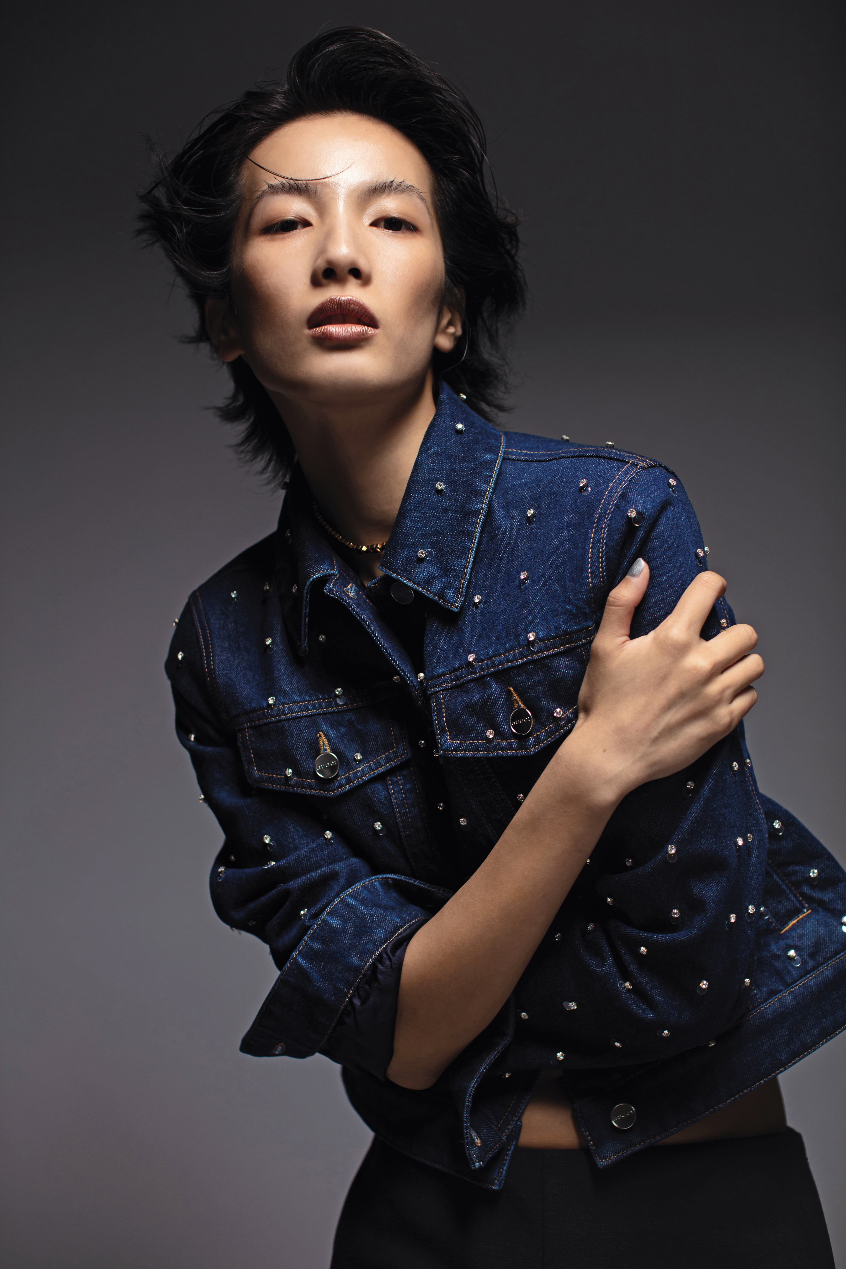 飾水晶丹寧夾克 NT$122,000 by Gucci／深灰開衩中裙 NT$57,000 by Gucci／金色飾面TRIOMPHE LINK短項鍊 NT$43,500 by CELINE BY HEDI SLIMANE