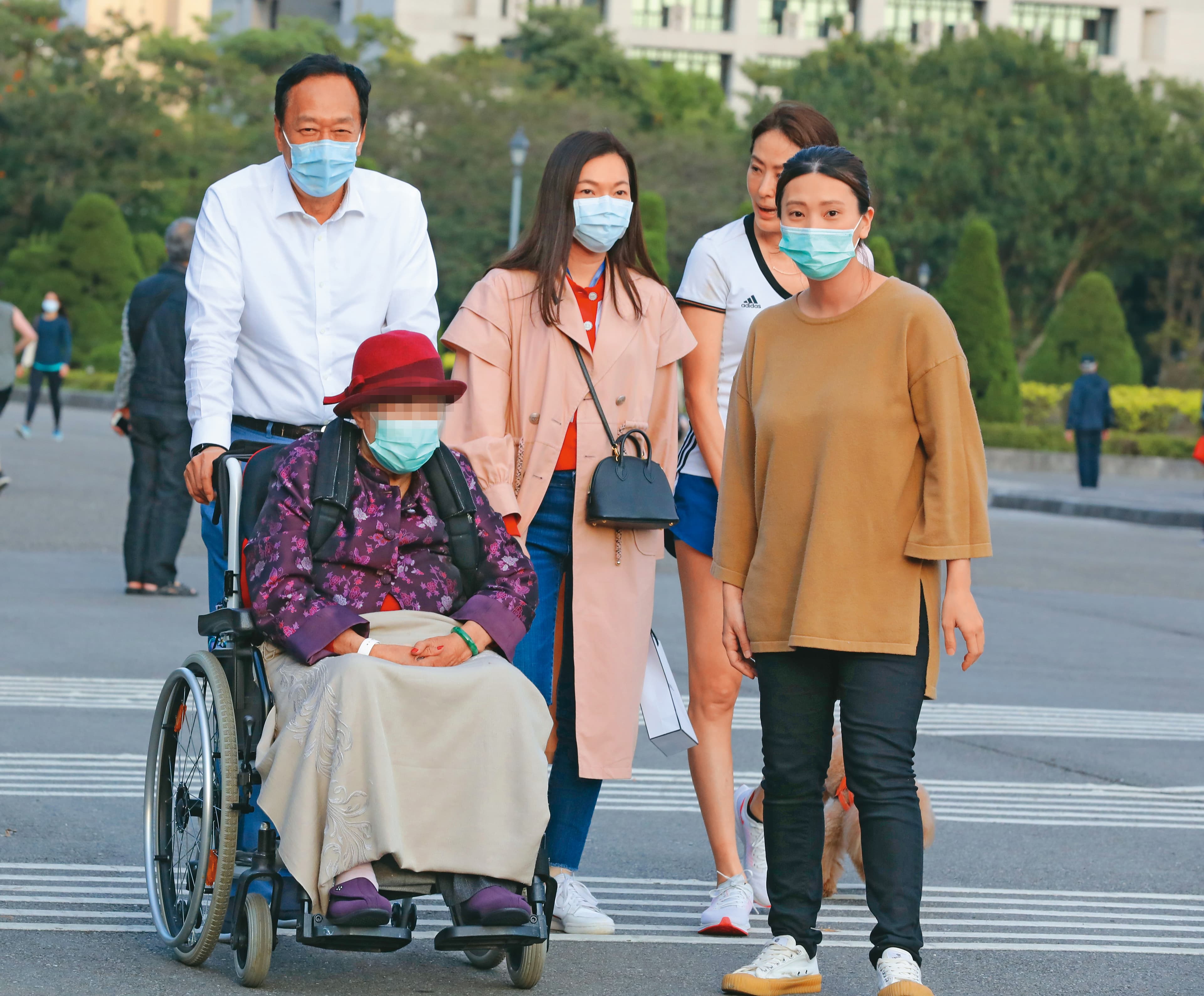 郭台銘(後排左一)與曾馨瑩(後排左二)陪郭媽媽(前)到國父紀念館散步,一路細心照料長輩。