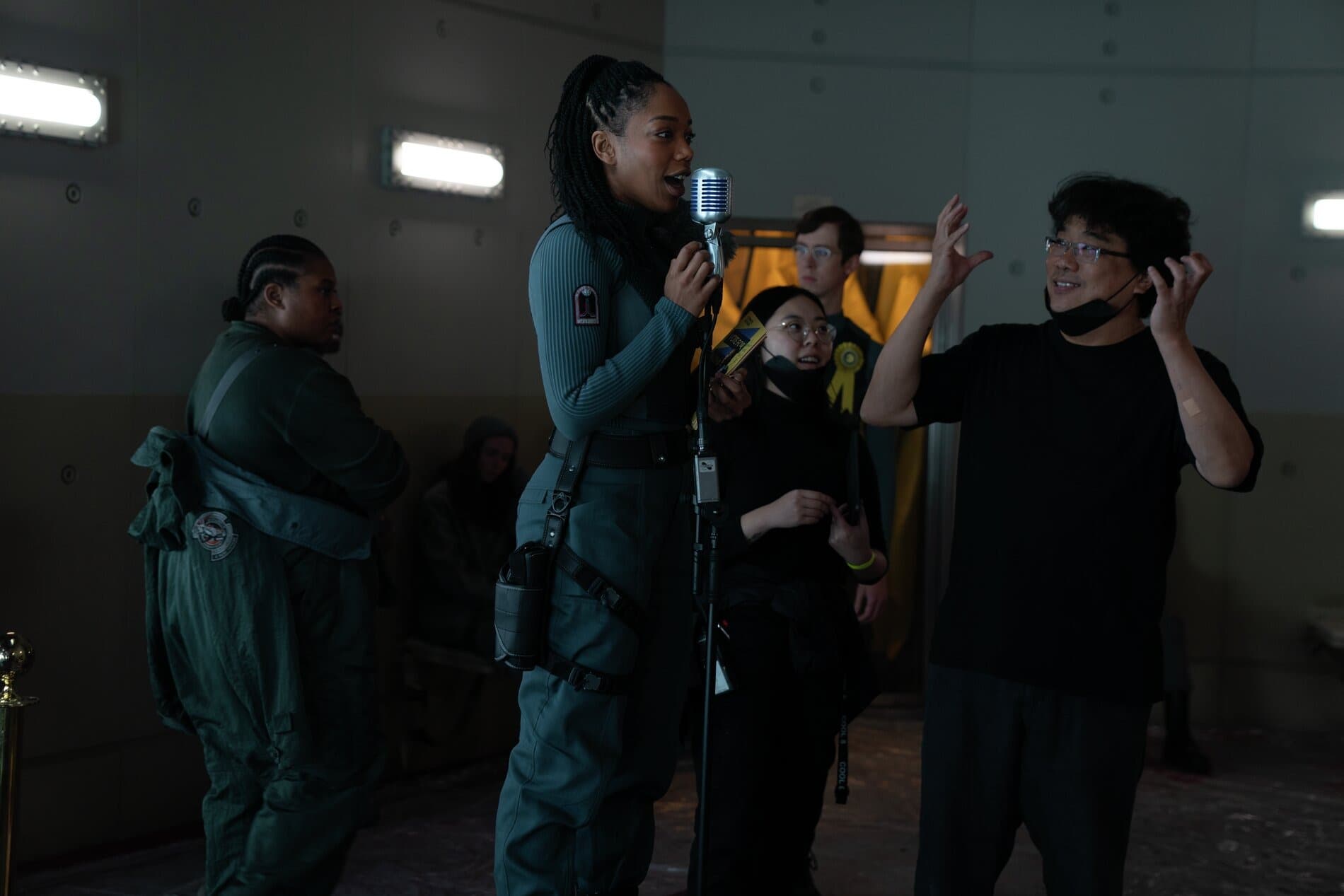 《米奇17號》是奉俊昊(右)第三部英語電影,在片場他透過口譯Sharon Choi(中)來與演員娜歐蜜艾基溝通。(華納兄弟電影提供)