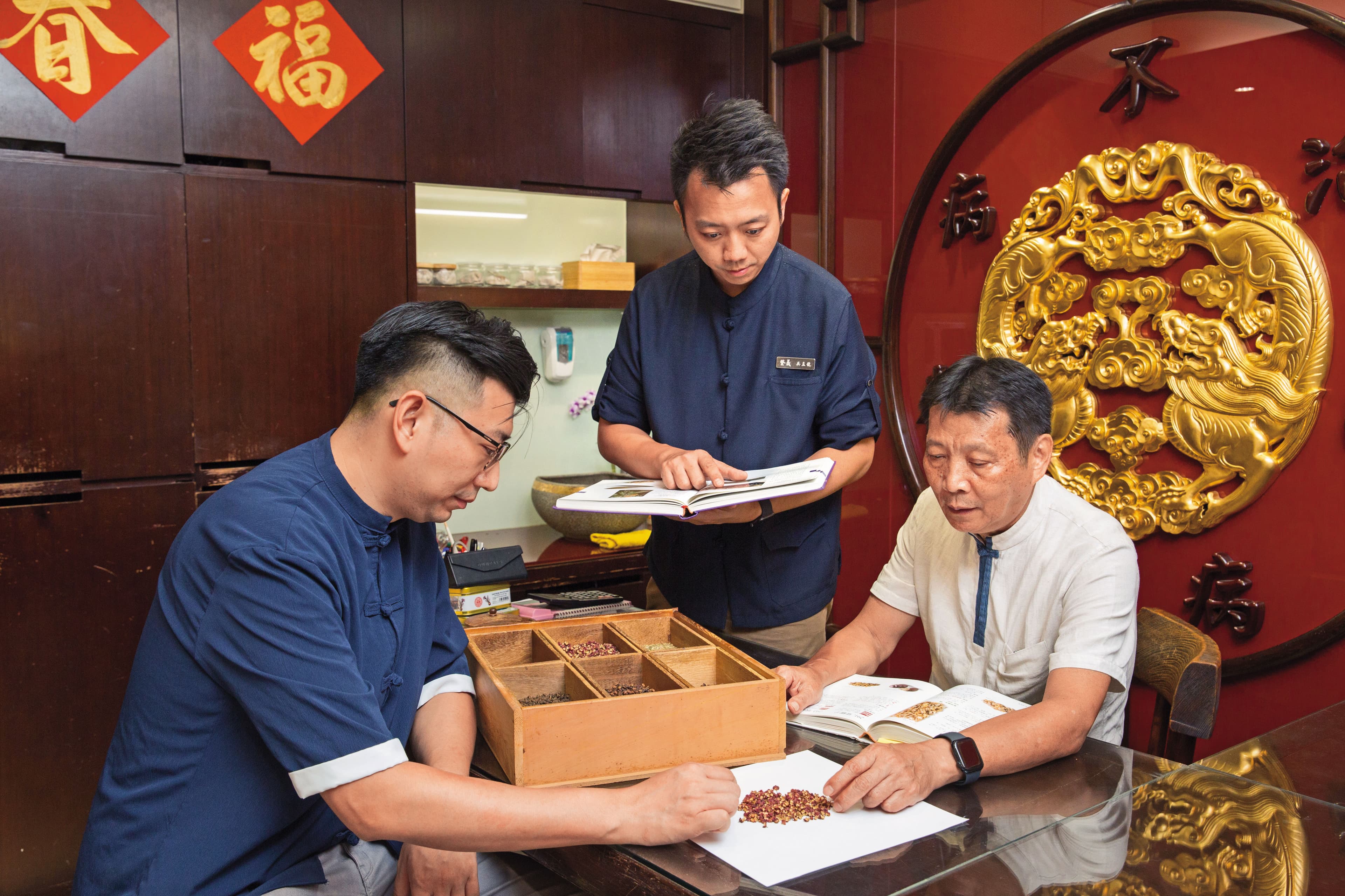 吳瀛洲(右)是店內的中藥活字典,兒子吳孟龍(中)與吳孟宸(左)常與他討論藥材應用。
