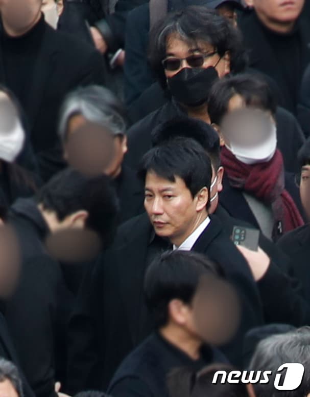 《寄生上流》奉俊昊導演(後)戴著墨鏡低調在人群中,前為金南佶。(翻攝自news1)