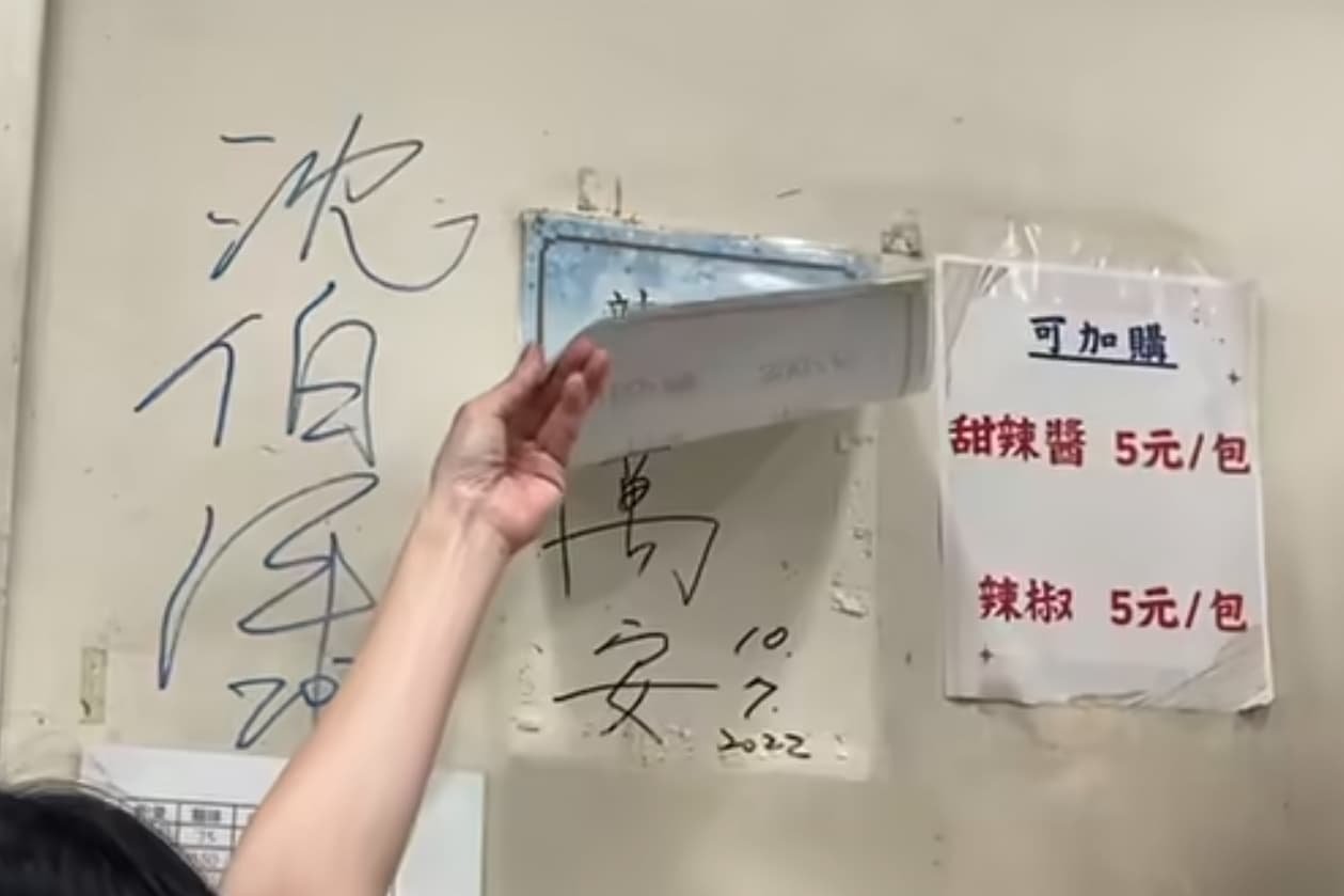 店家老闆娘熱情掀開一旁貼著的菜單，意外露出台北市長蔣萬安在2022年競選期間留下的簽名。（翻攝自周軒臉書）