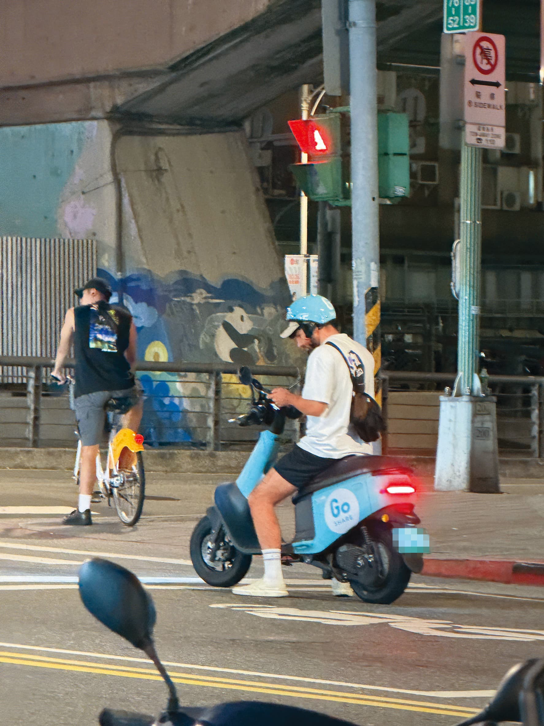 酷被民眾目擊在台北市街頭違規,騎車滑手機。(讀者提供)