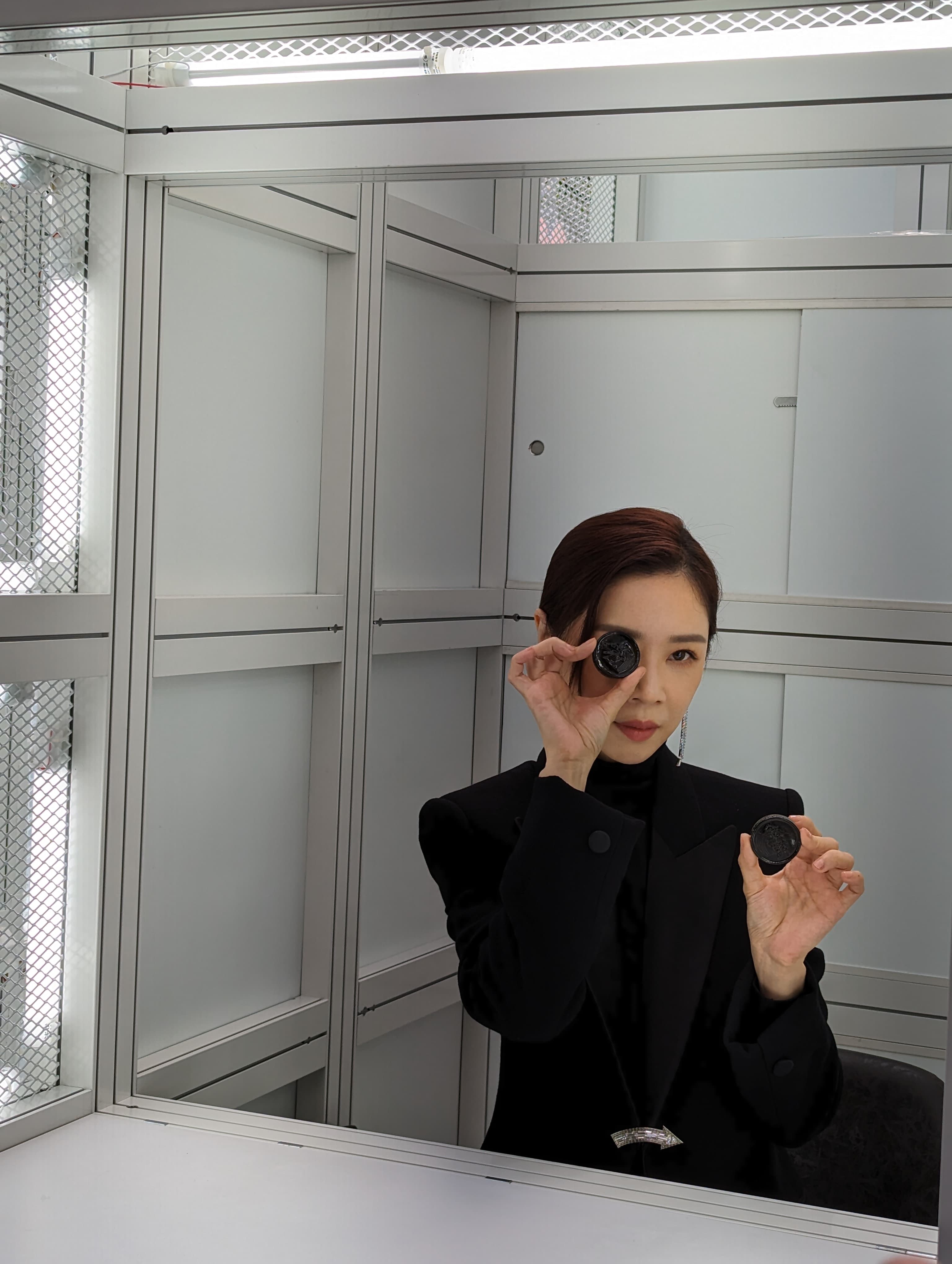 謝盈萱受訪前又大發戲癮,扮演起窗口老闆娘,還拿起代幣把玩,酷酷地拍照。(熊景玉攝影)
