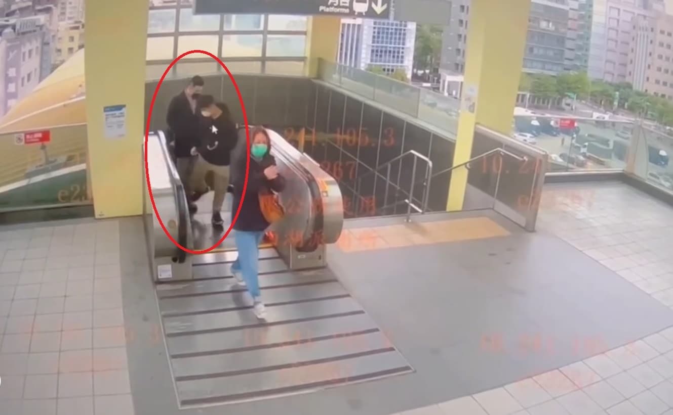 林男在電扶梯上轉身用右腳踩羅男的腳報復。(翻攝畫面)
