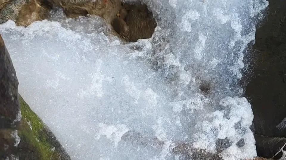 今日上午位於上游處的暖暖溪卻突然出現許多白色不明泡沫。(翻攝畫面)