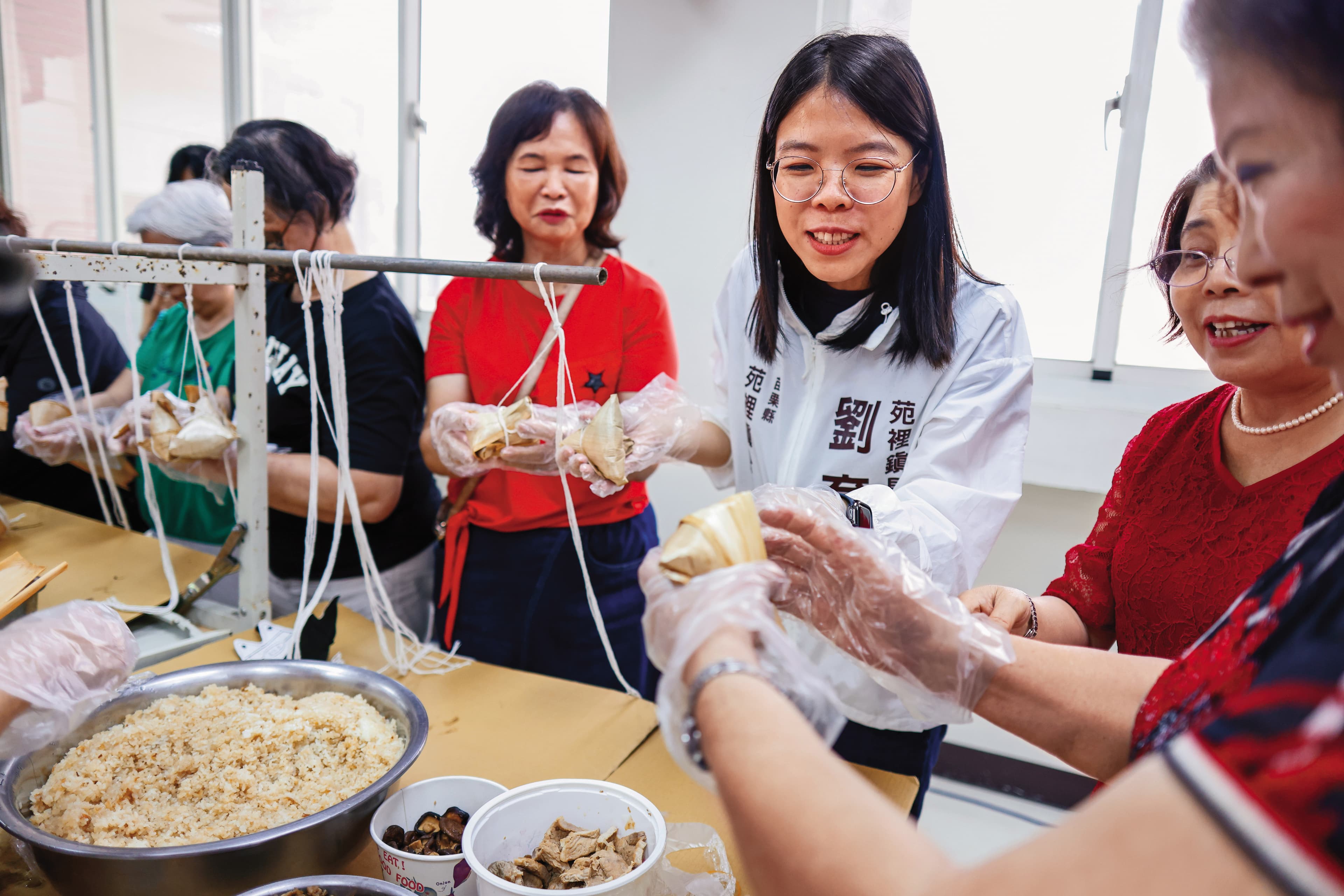 劉育育(中)與婆婆媽媽們一起包端午節粽子。