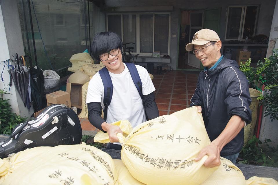 盧廣仲幫忙搬運、分裝稻米,體驗務農生活,一旁小農賴青松是知名的自願農民。