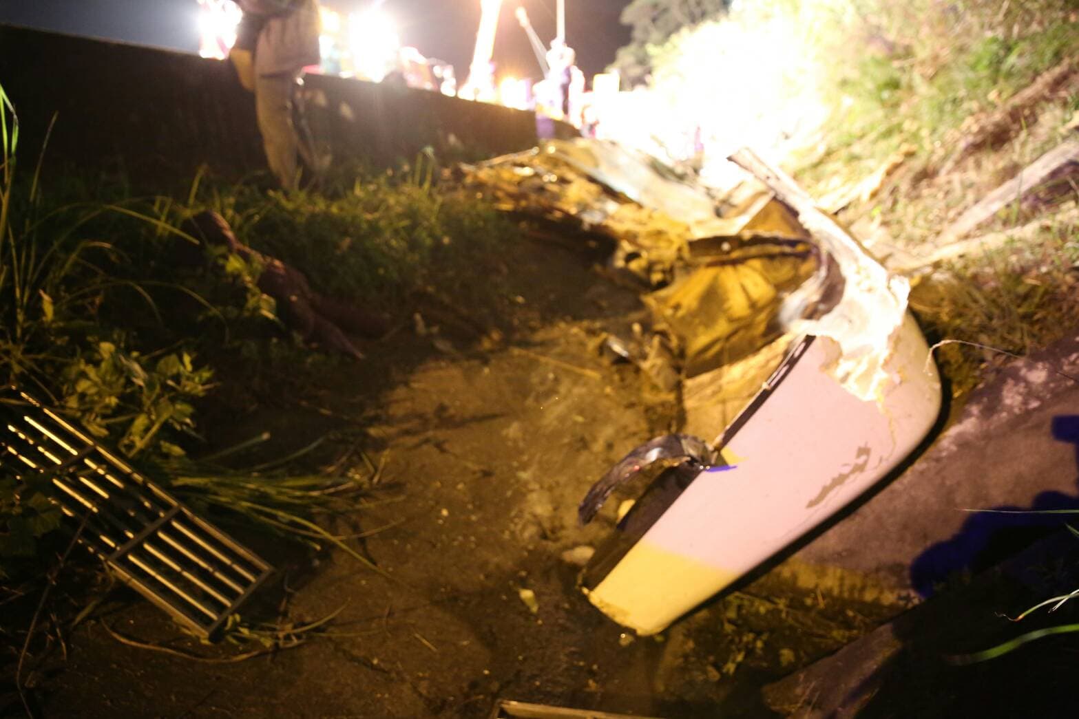 事發現場,翻覆的遊覽車撞段護欄。