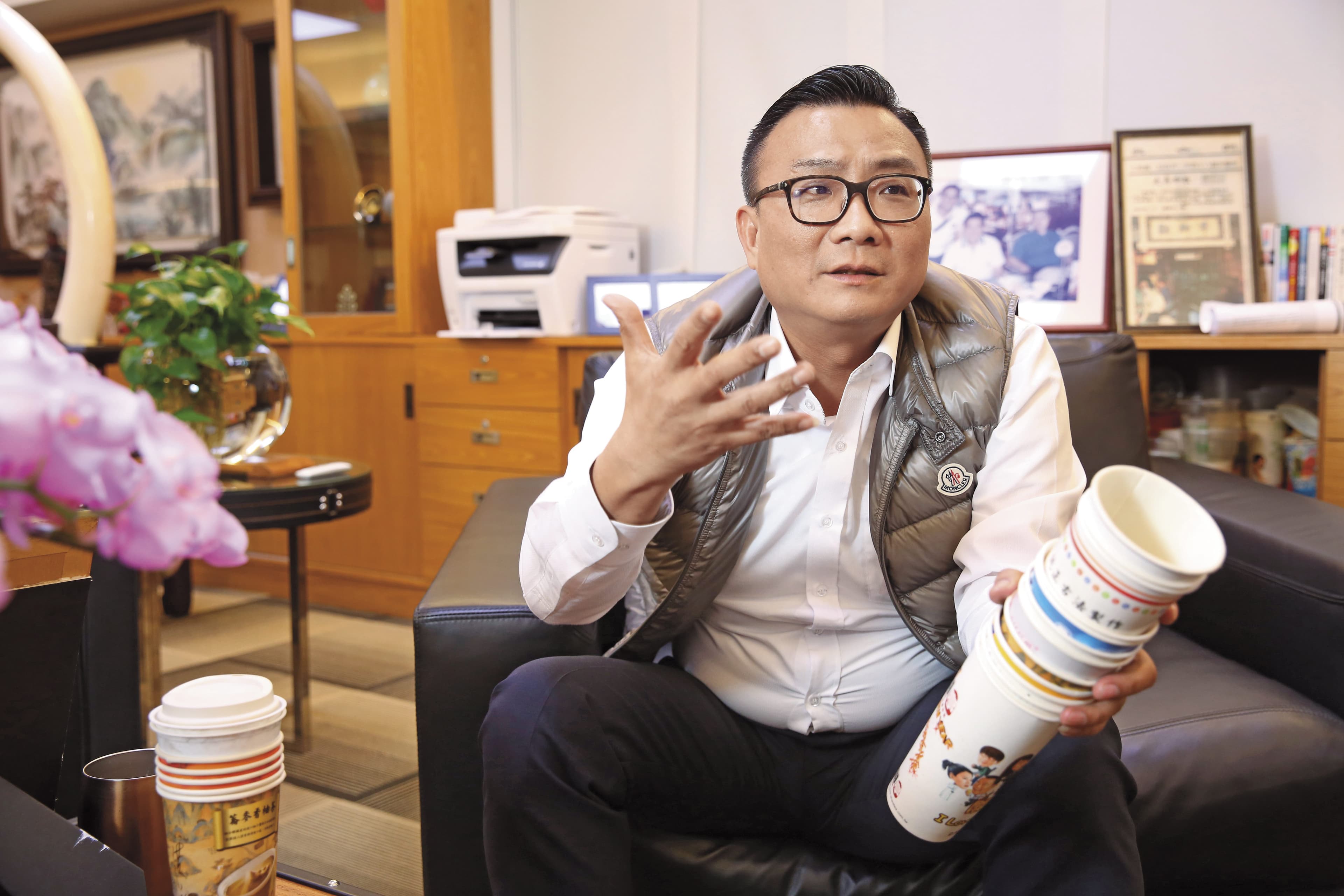 拿著歇腳亭歷代飲料杯,鄭凱隆很驕傲自己首創飲料界的異業結盟,能將杯身當廣告賣,不只可以賺錢,還能提供客人贈品。