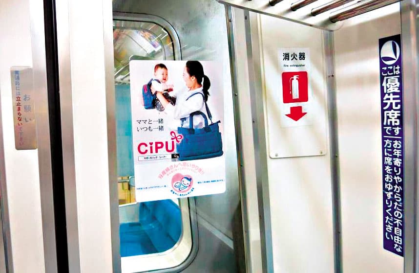 去年11月,東京地鐵大江戶線車廂宣傳「孕婦優先席」的海報上,母子背著喜舖包,目前在新加坡、馬來西亞、香港等地,都有喜舖的實體門市。(周品妤提供)