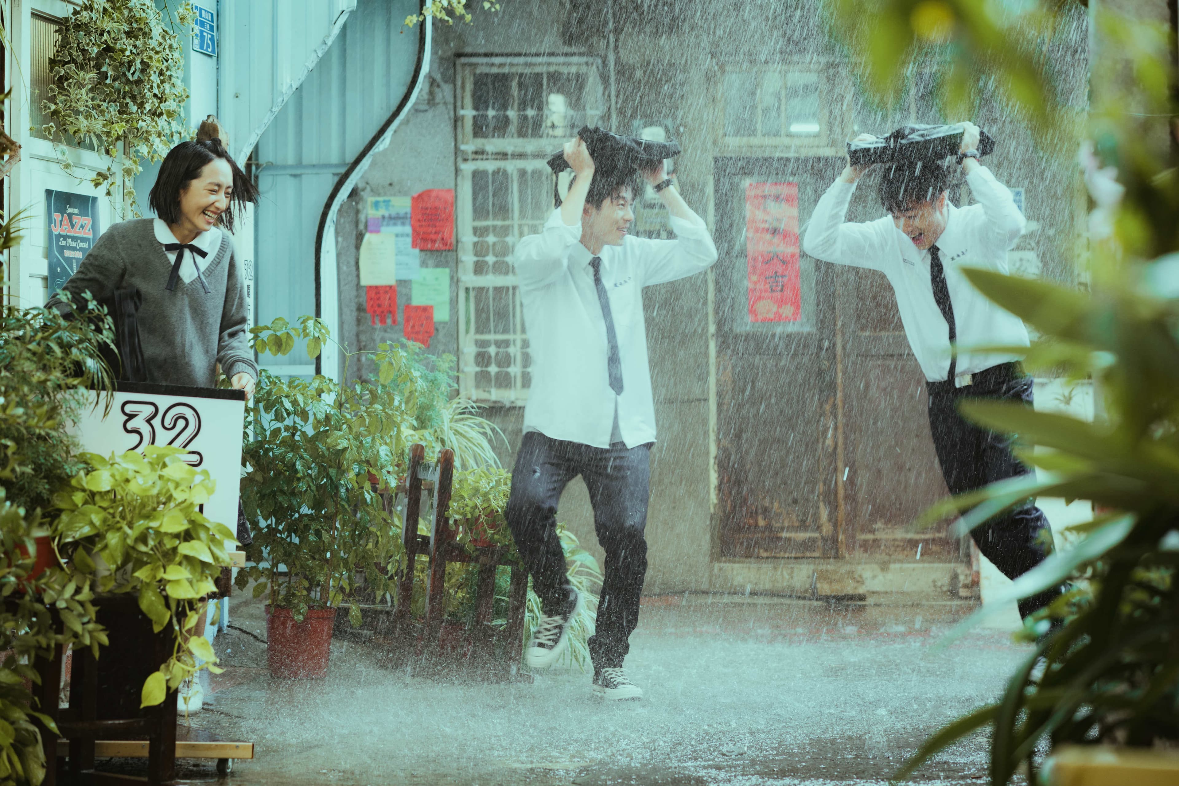 柯佳嬿(左起)、許光漢、施柏宇在雨中嬉鬧,感情超好。(福斯傳媒集團提供)